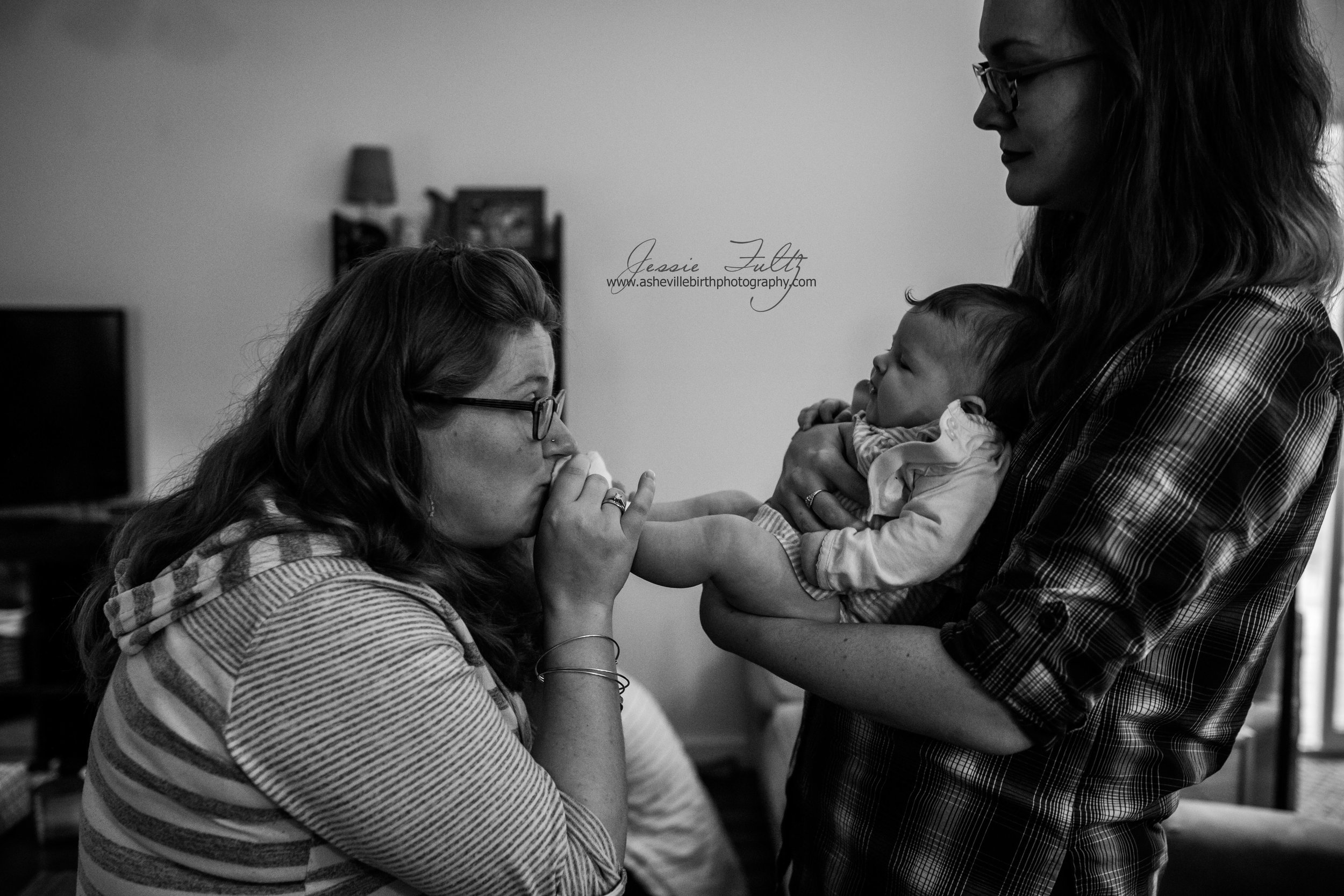 pregnant woman kissing an infant's feet