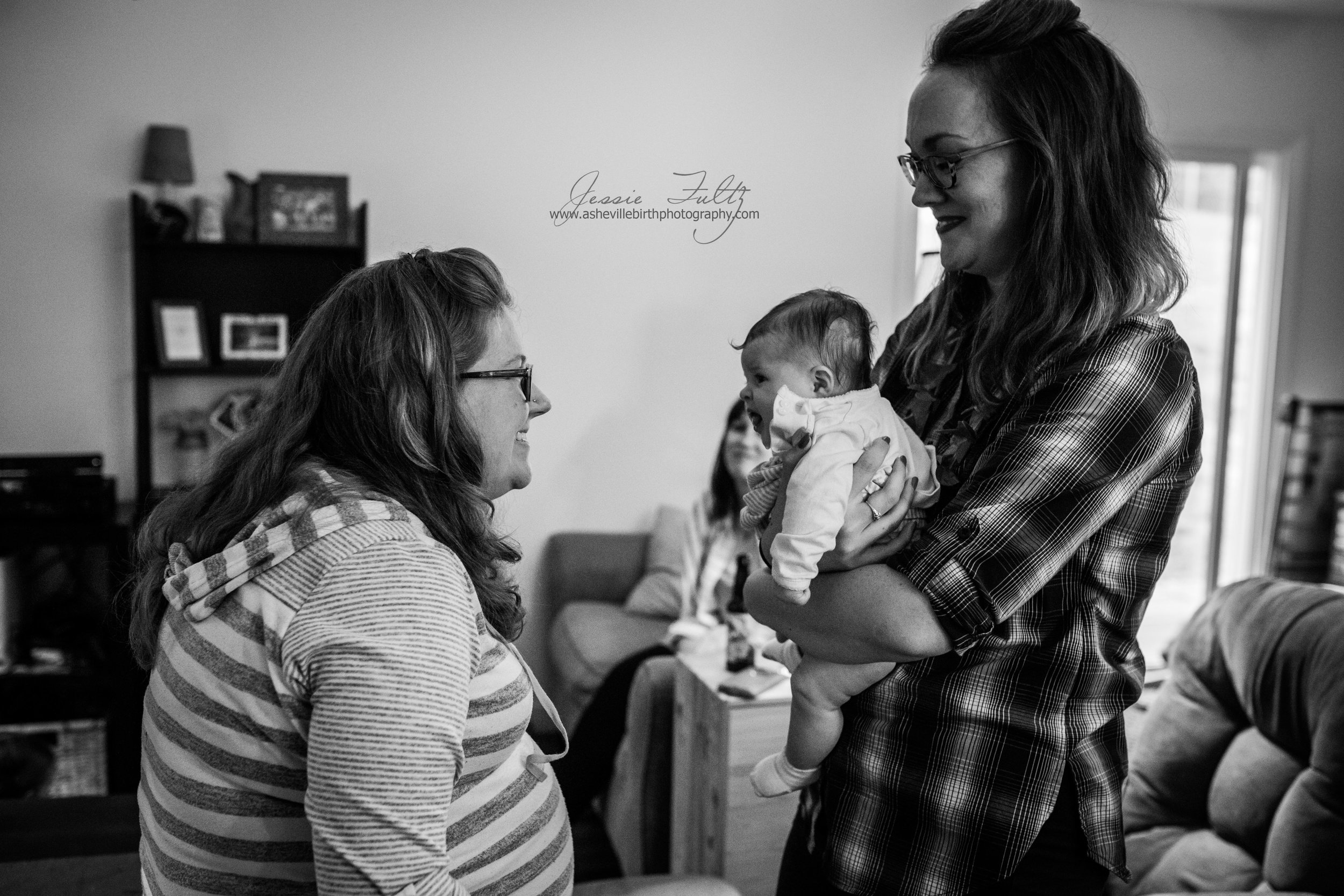 pregnant woman smiling at an infant