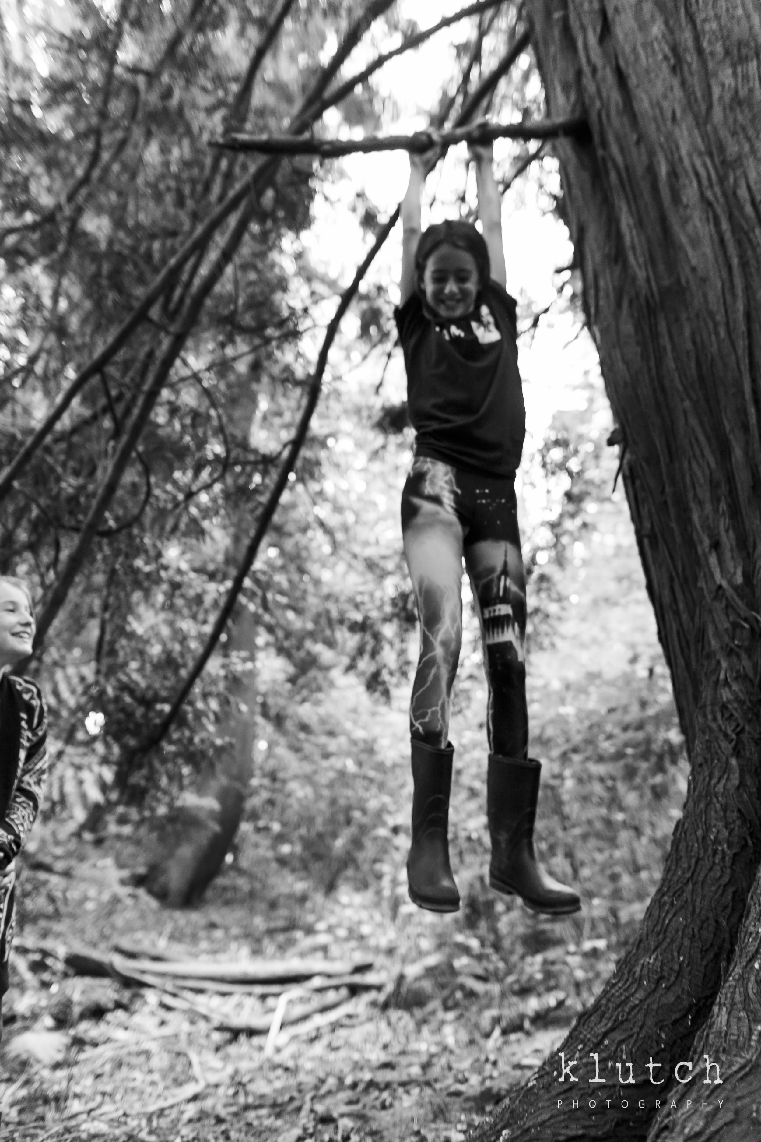 Girl dangling from tree branch