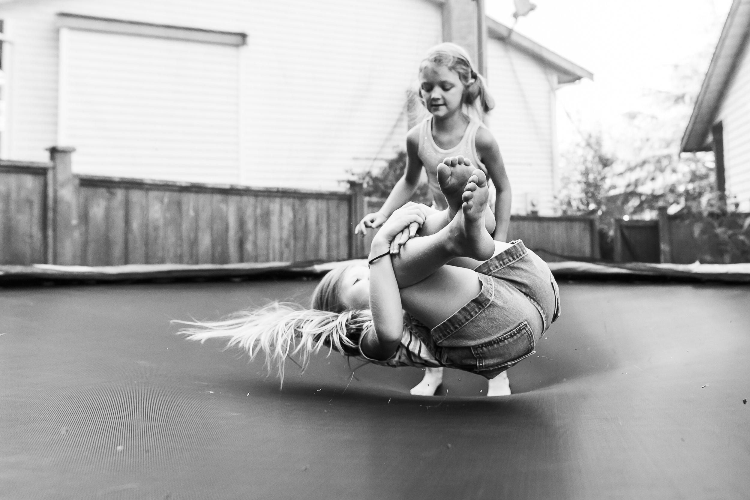 Surrey Family photographer. Vancouver family photographer, klutch Photography, documentary photography, candid photography, trampoline jumping over sisiter
