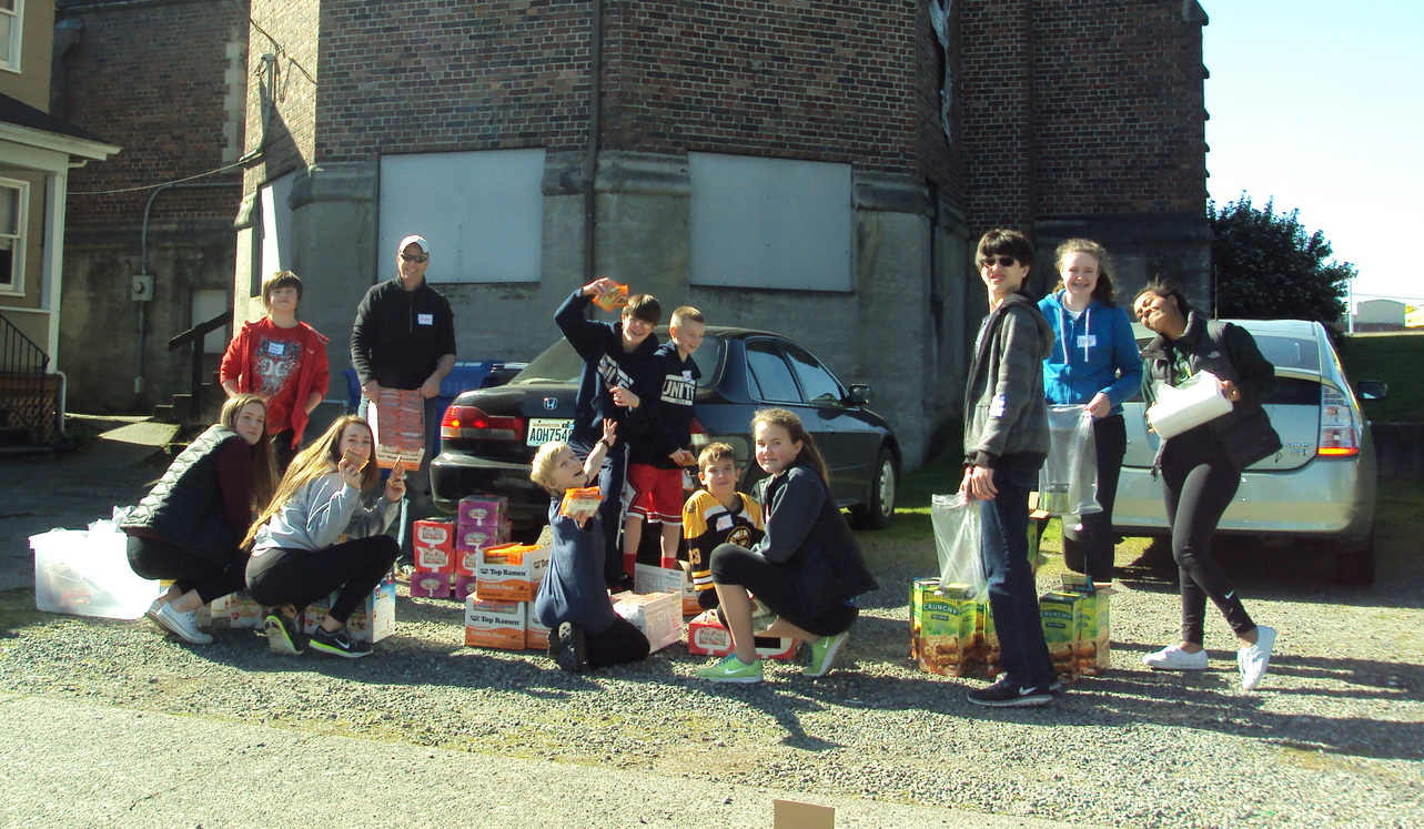 Trinity's Youth assemble food packs for the ministry at St. Leo's.