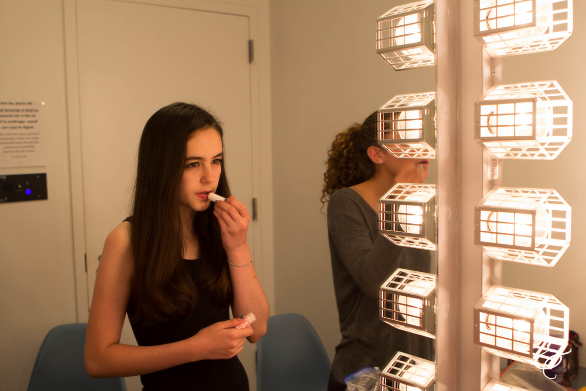 Angela putting on stage make-up backstage in May 2015.