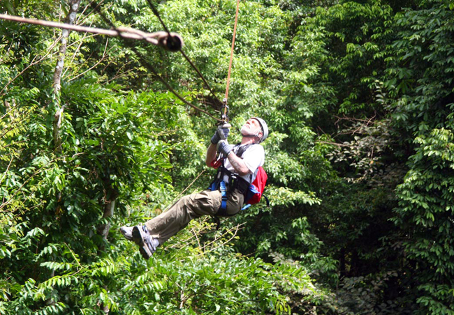 Les zip-lining about 100 feet above the tropical Costa Rican forest (2011).