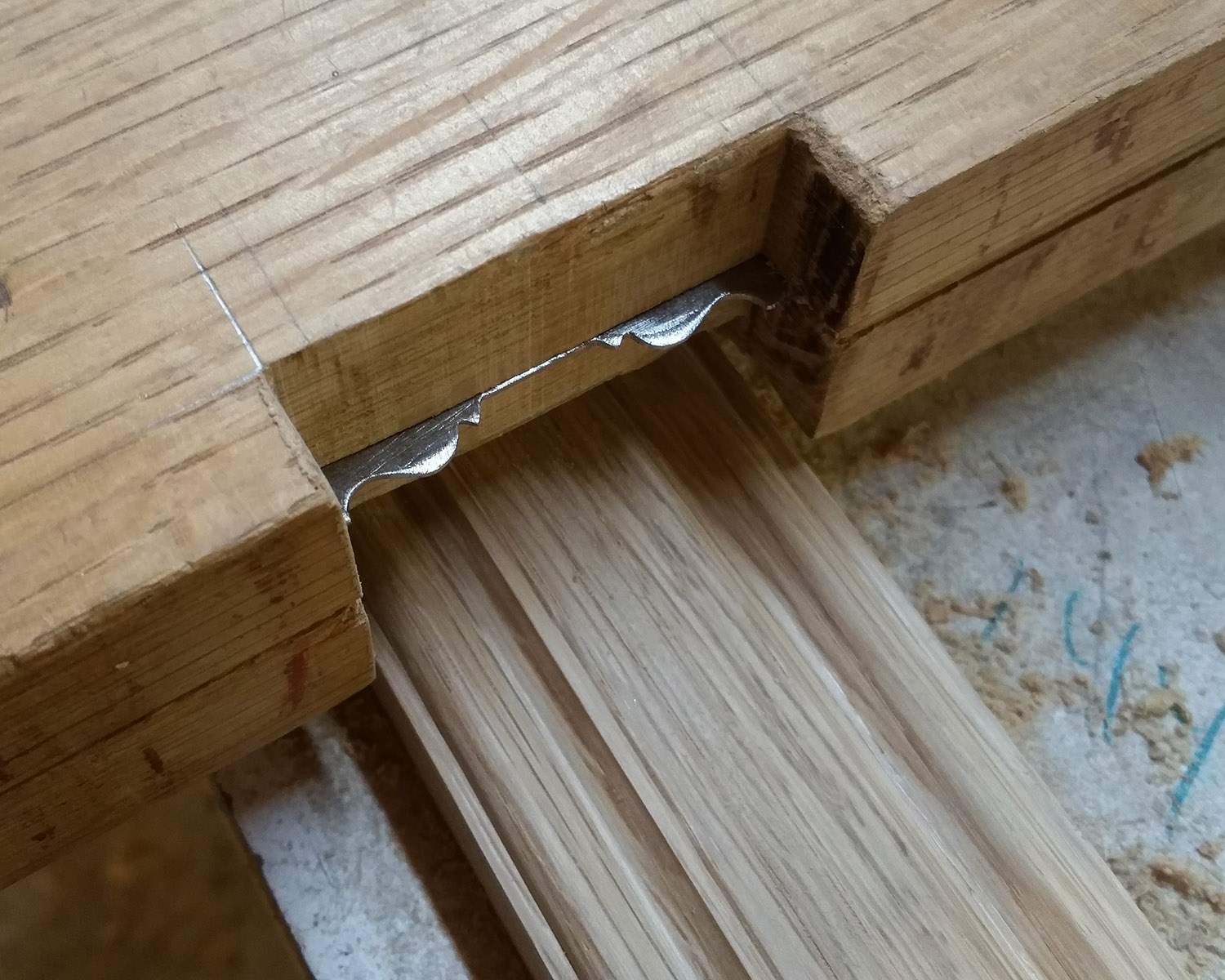 Mount the scraper between to thick pieces of wood, which have been notched to very slightly over the size of the stock you'll be profiling.