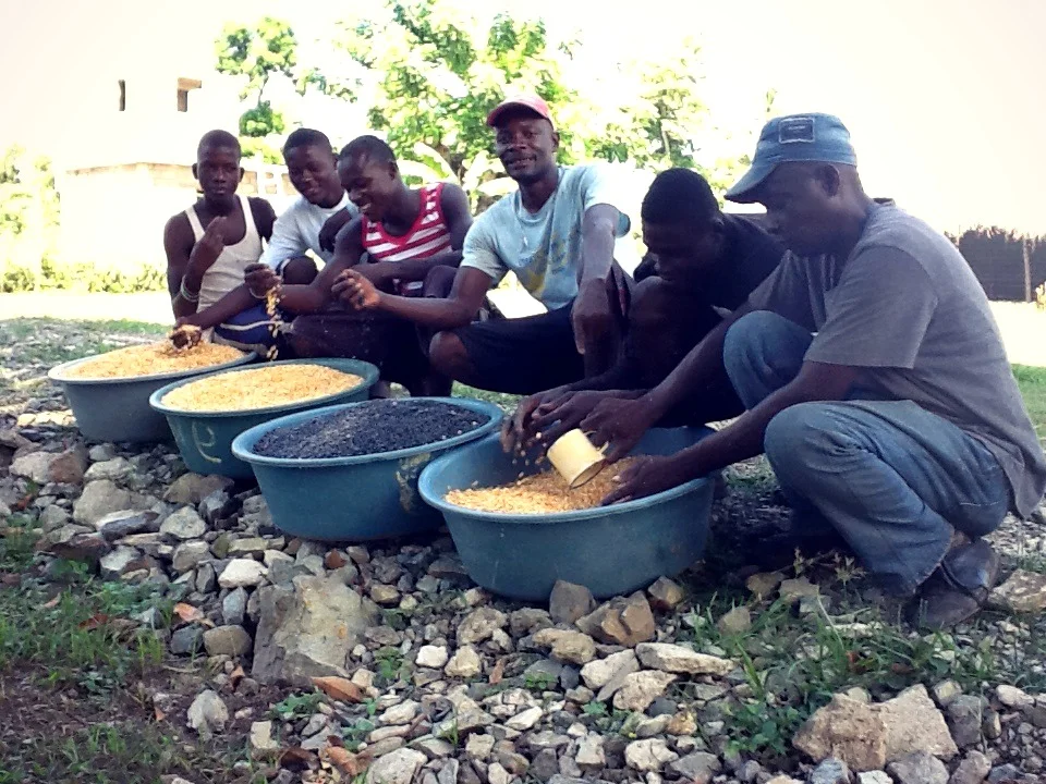 Joseph with employees showing off a recent corn and bean harvest 