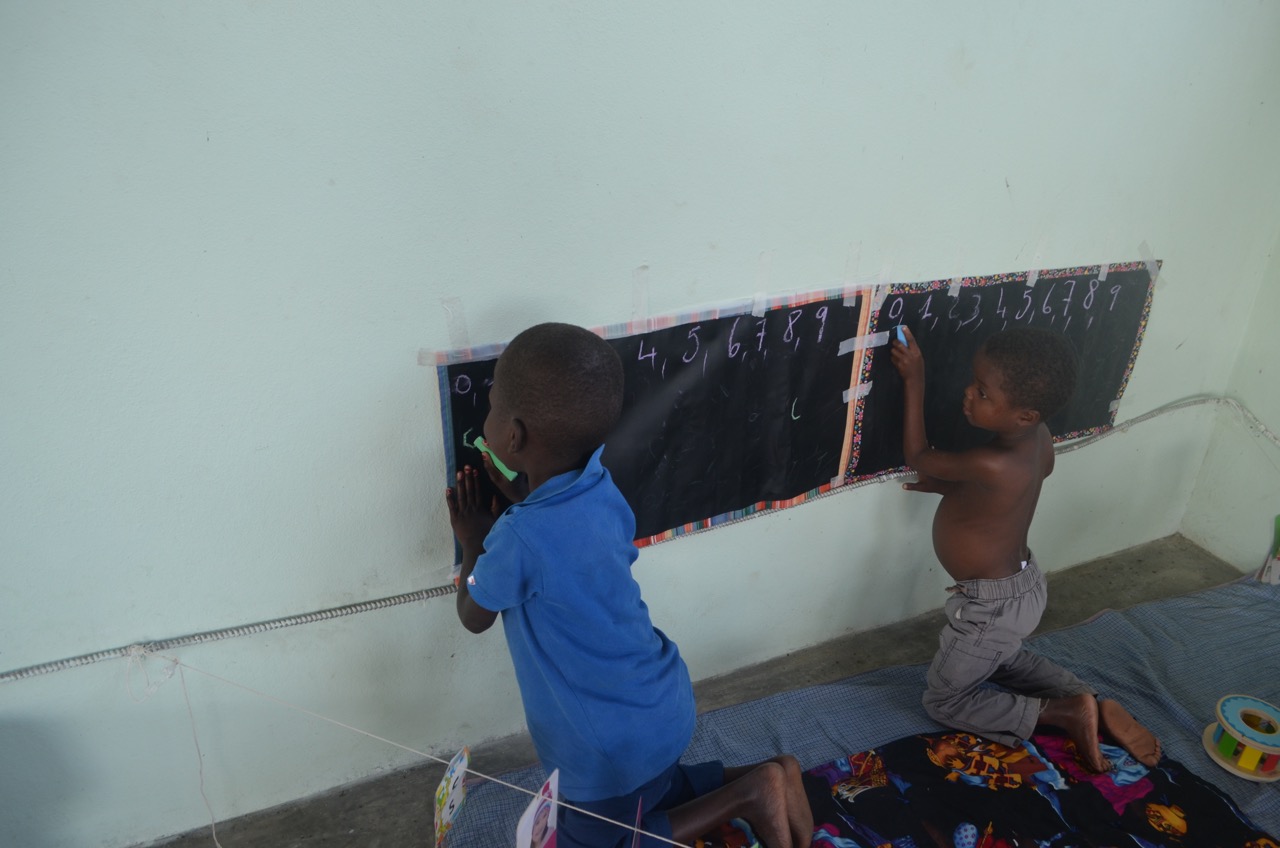 Kely (8) and Jameson (6) practice their school lessons while recovering from Severe Acute Malnutrition at Second Mile Haiti