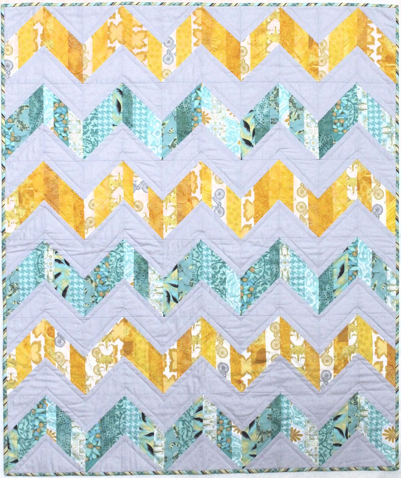 The original quilt used light gray and modern fabrics in teal and yellow