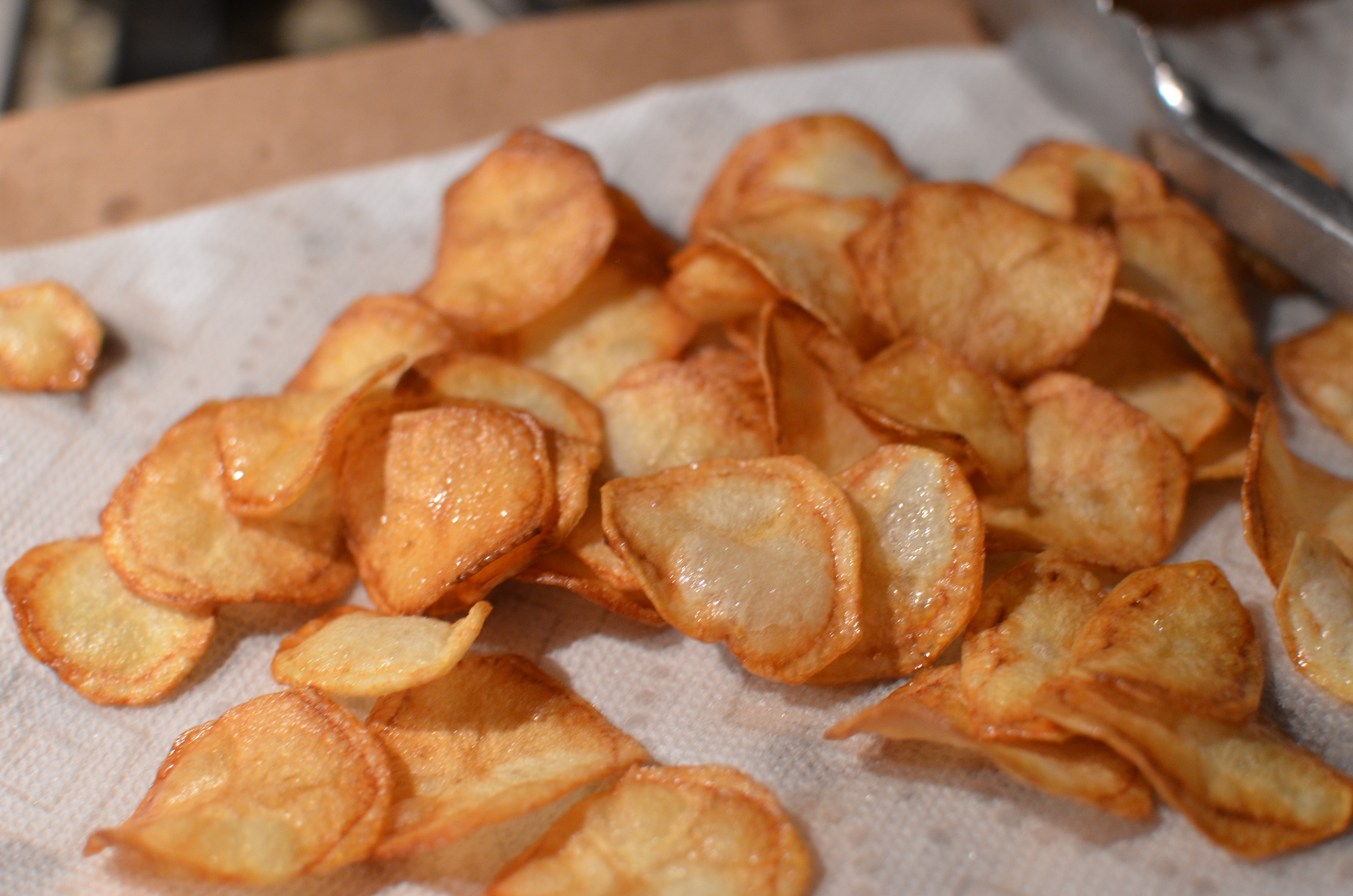 Drain chips on paper towels and sprinkle with very finely milled popcorn salt while they're still warm. Because the popcorn salt is so finely milled, it sticks to the chips better than table or kosher salt.