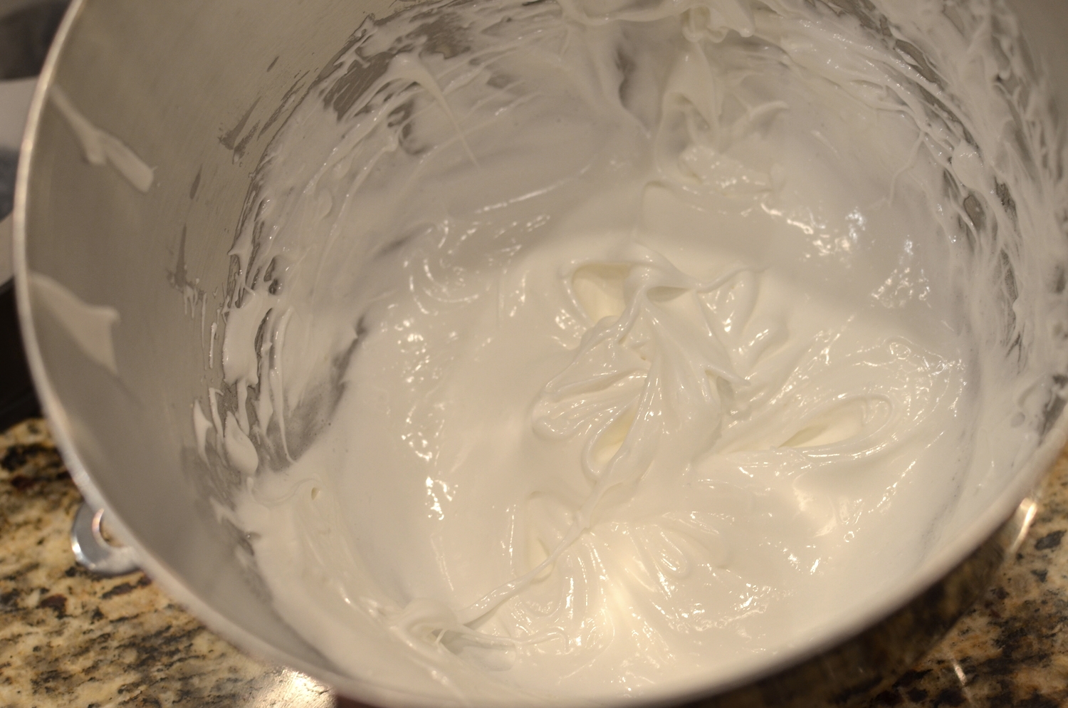 Add the sugar and continue whipping the egg whites until stiff peaks form. Not quite there yet, but soon. 