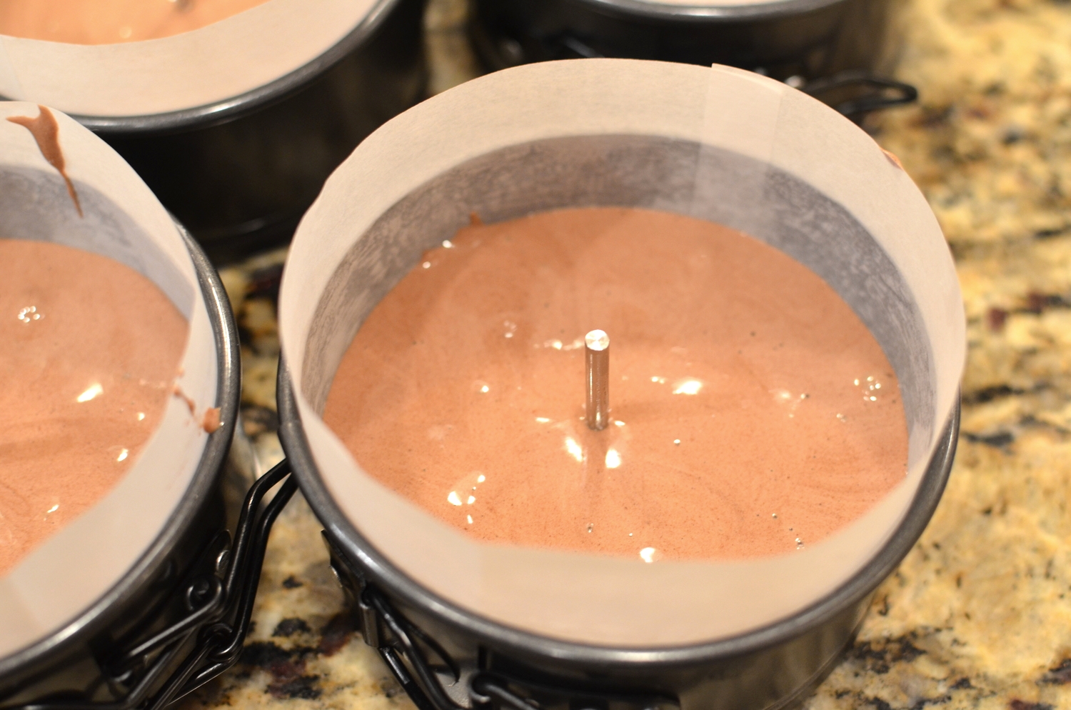 Pour the batter into prepared pan(s). Press upside down flower nail or Ateco heating cores into the center of the batter, pressing the flat head down completely so it sits flush against the bottom of the pan(s).