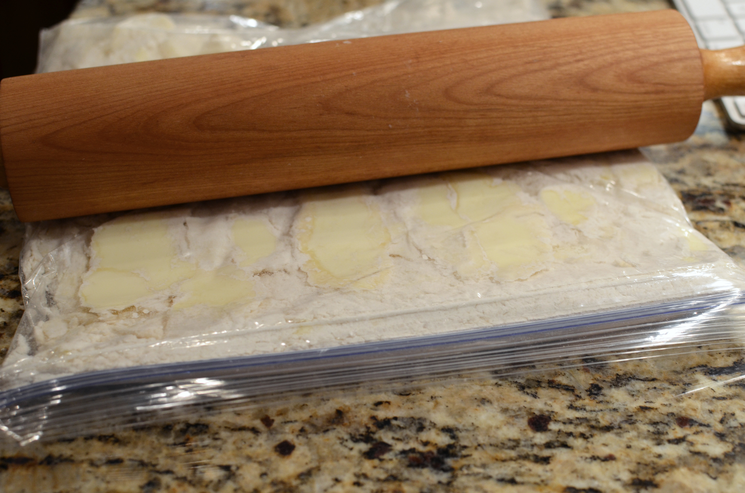 Remove as much air as possible from the bag and seal it closed. Use a rolling pin to flatten the frozen butter cubes into thin flakes. Sounds easy enough, but I found it very frustrating. The frozen butter doesn't want to cooperate at all. What it did want to do was stick all over the inside of the bag. I tried to reduce the sticking by redistributing the flour in the bag, but since all the air had been squeezed out of the bag, a sort of vacuum had been created and the flour didn't want to flow freely from one part of the bag to another. Whatever, I was over it by this time so when I felt that I had rolled the butter to my best ability, the bag was placed back in the freezer for 10 more minutes, as directed.