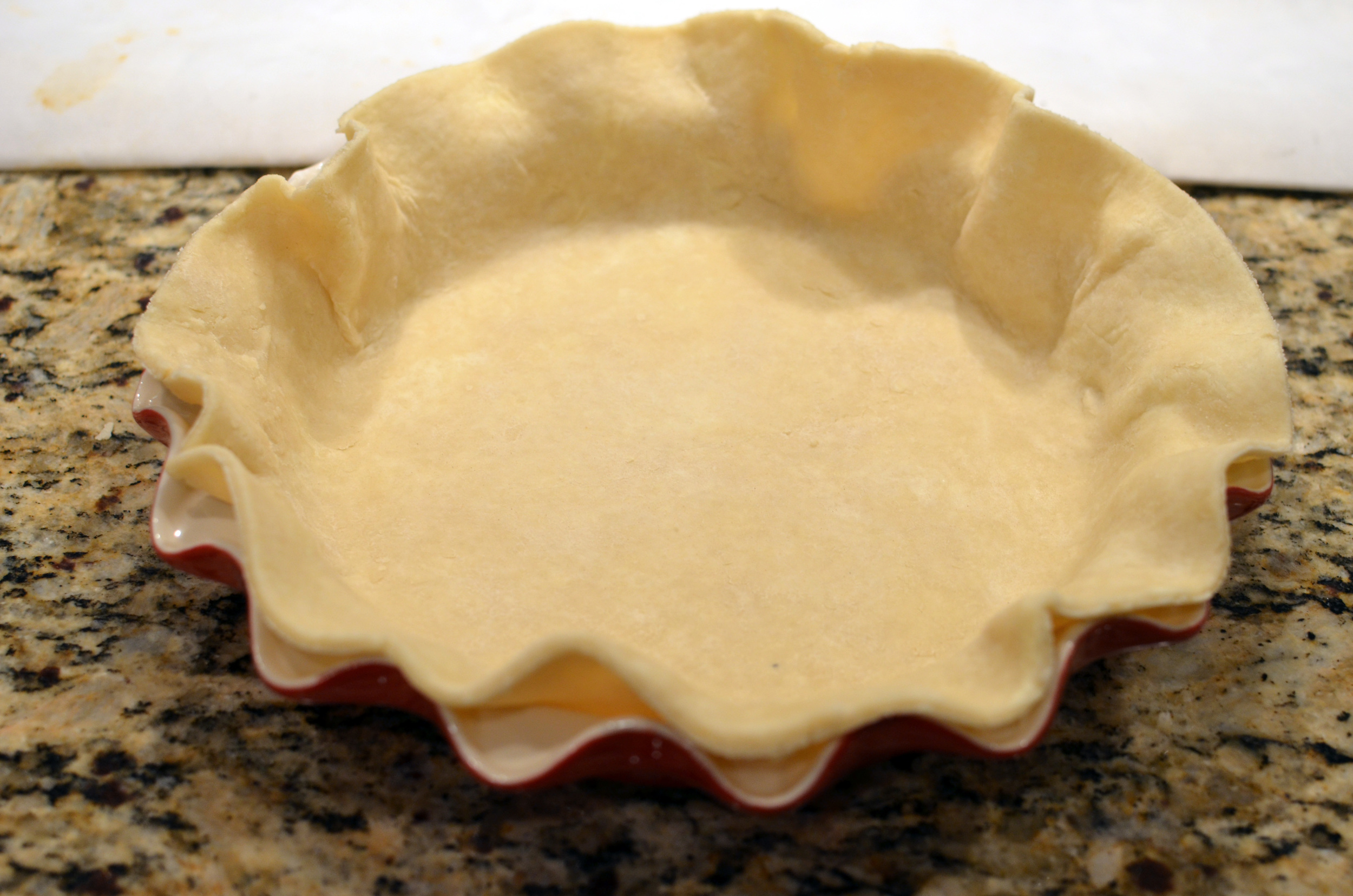 Place the crust in the pie plate. Cutting the dough ahead of time eliminates the need to trim excess dough at this point. Okay, let's make the filling. 