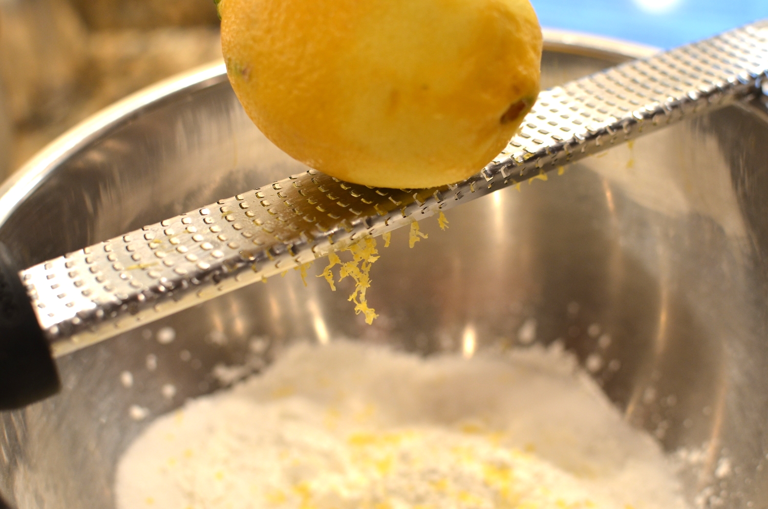 In the bowl, sugar, cornstarch, and salt. We're also going to add lemon zest. A microplane grater is the perfect tool for this. I grates the zest into fine bits.
