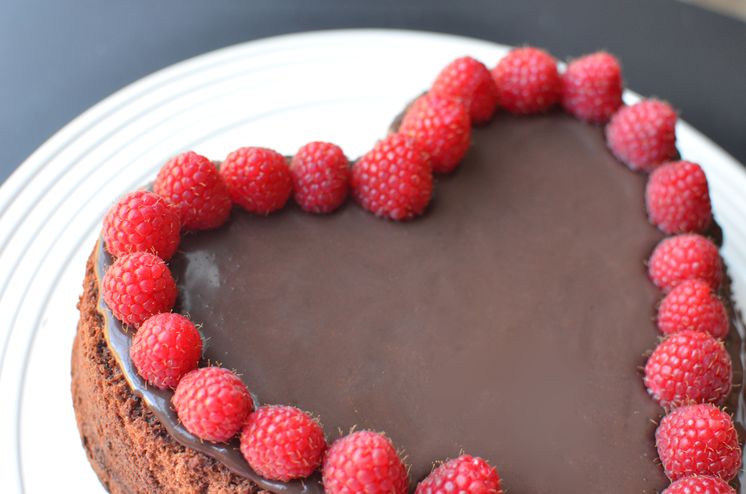 Once the cake has cooled completely, decorate it with the ganache we made earlier in the day. My ganache wouldn't hold any swirl designs so I just spread it out flat - the cake looked really boring so I added fresh raspberries. Much prettier. 