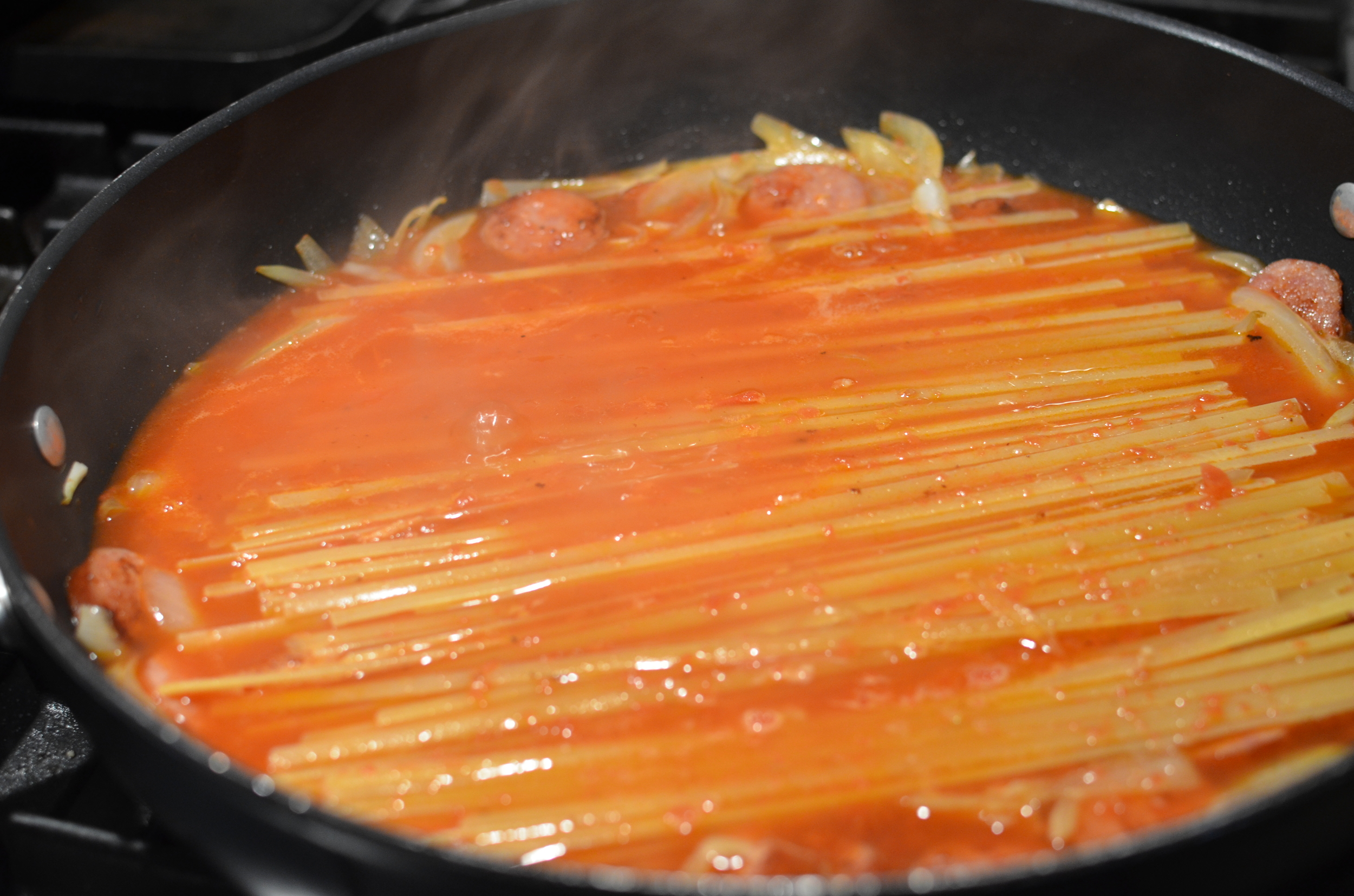 Press the fettuccine into the liquid and move it around a little to prevent the pasta from sticking together. Lower the heat back to medium.