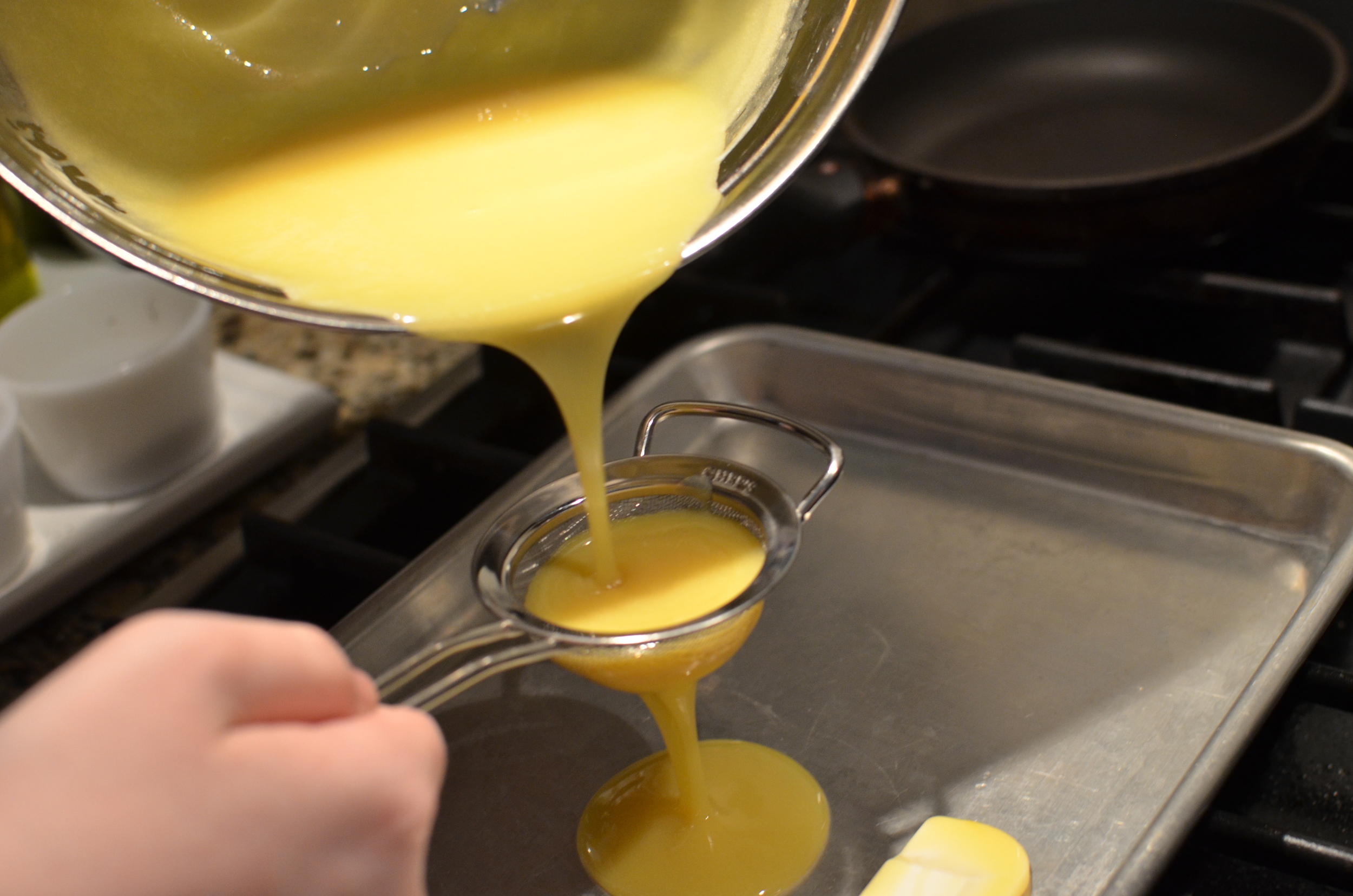 Strain the thickened custard through a fine mesh sieve. Cool mixture until it reaches 70F. 