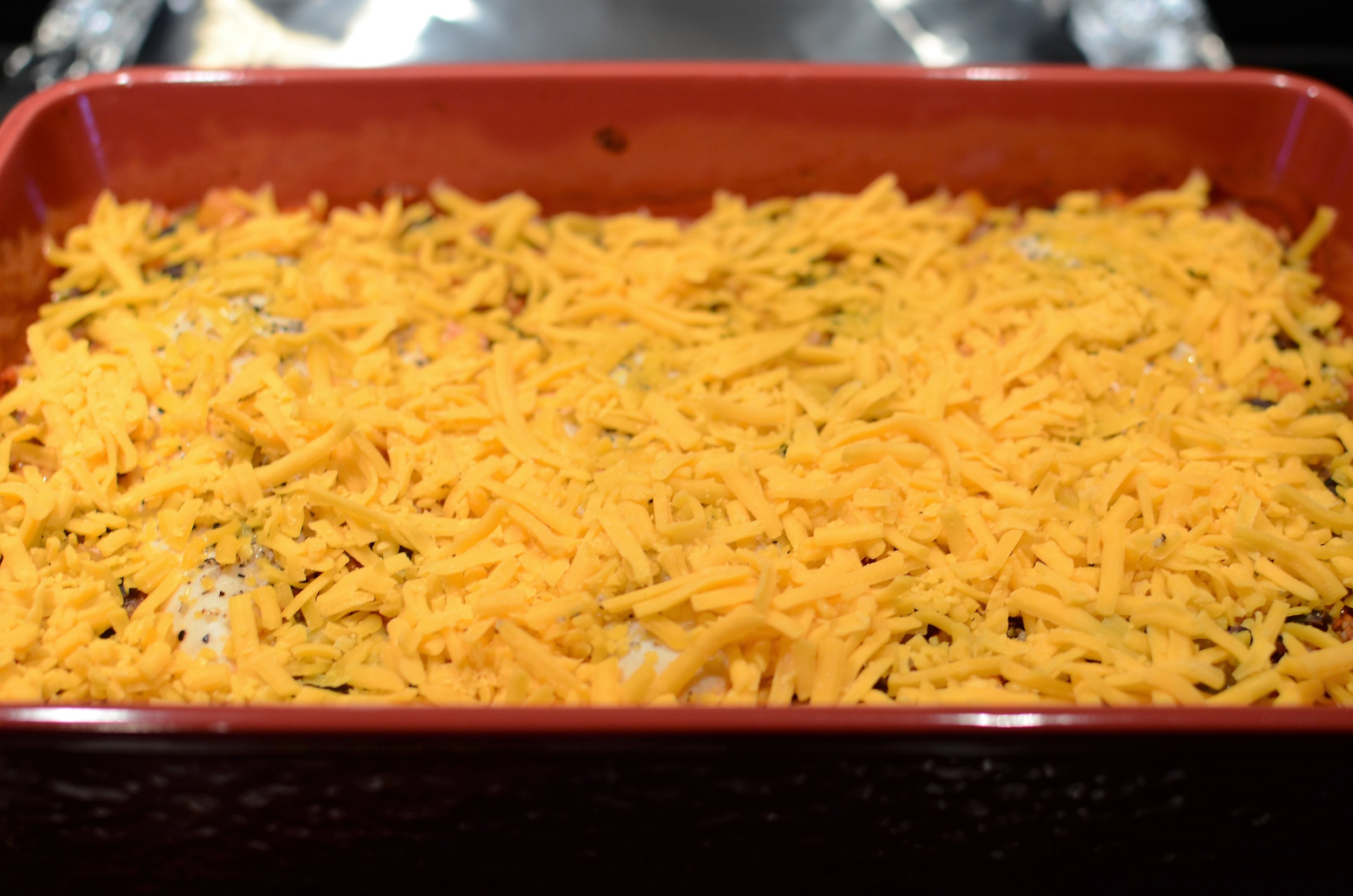 Uncover the casserole dish and sprinkle generously with grated cheddar cheese and pop back into the oven for just a couple of minutes to melt the cheese.