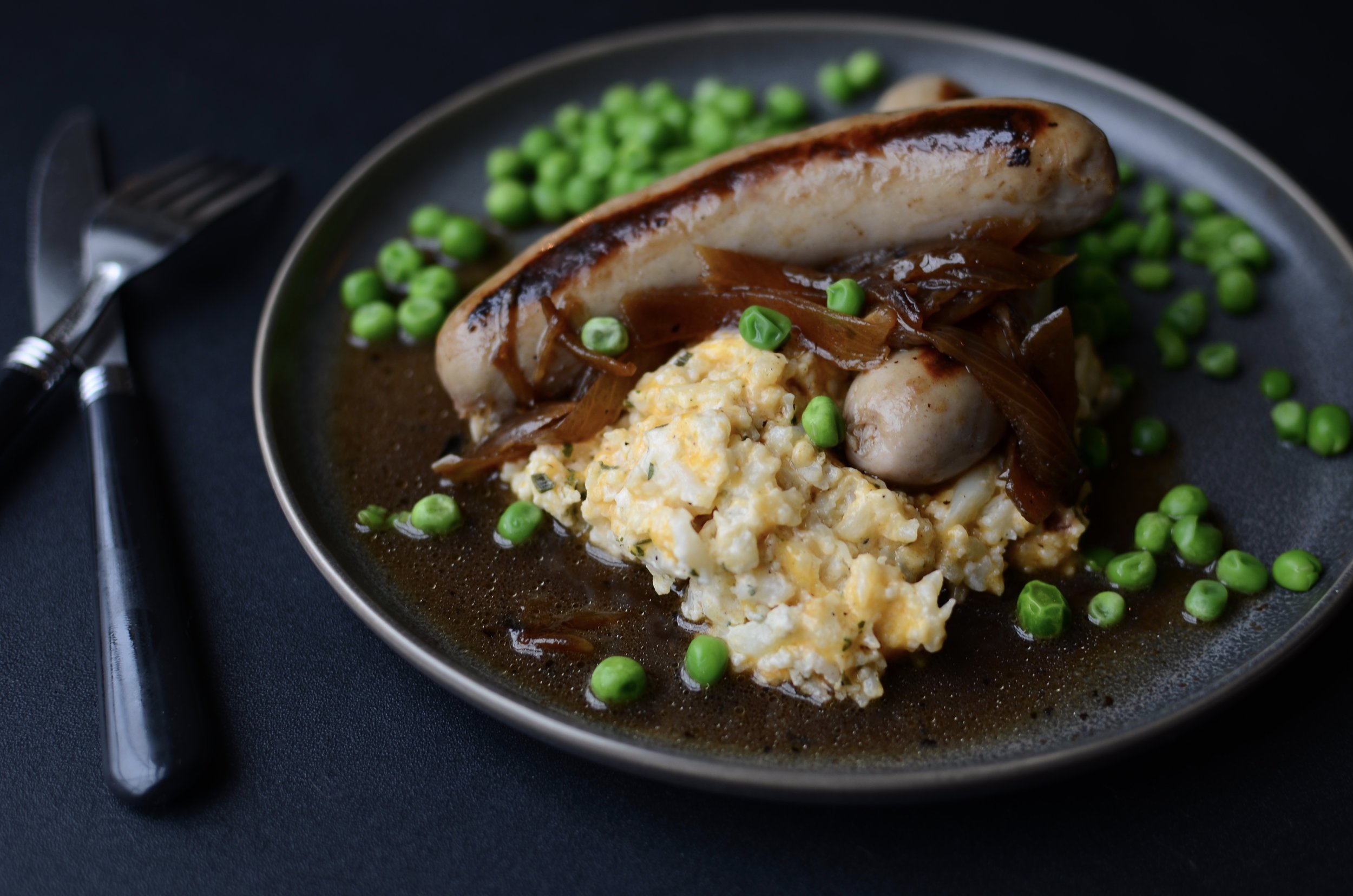 ketogenic bangers and mash recipe. how to make bangers and mash Keto-friendly. recipe for keto bangers and mashed cauliflower. keto recipes for st. Patrick’s day. keto st. Patrick’s day recipes. how to eat keto on st. Patricks day. Irish-style bangers and mash recipe. keto bangers and mash with onion gravy recipe. loaded mashed cauliflower recipe. keto mashed cauliflower recipe.