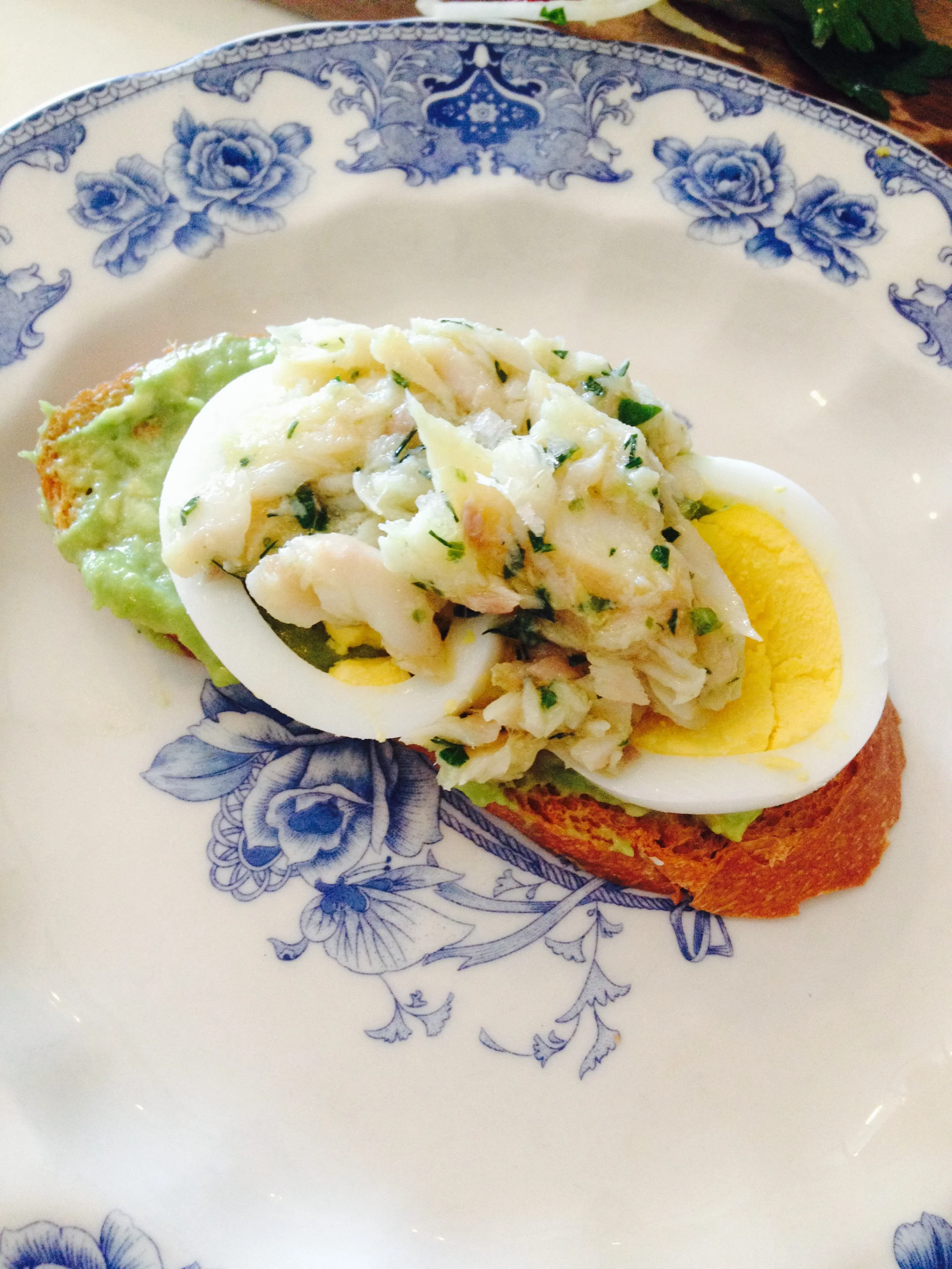 Smoked trout with boiled egg, pickled onion, capers, and avocado toast.