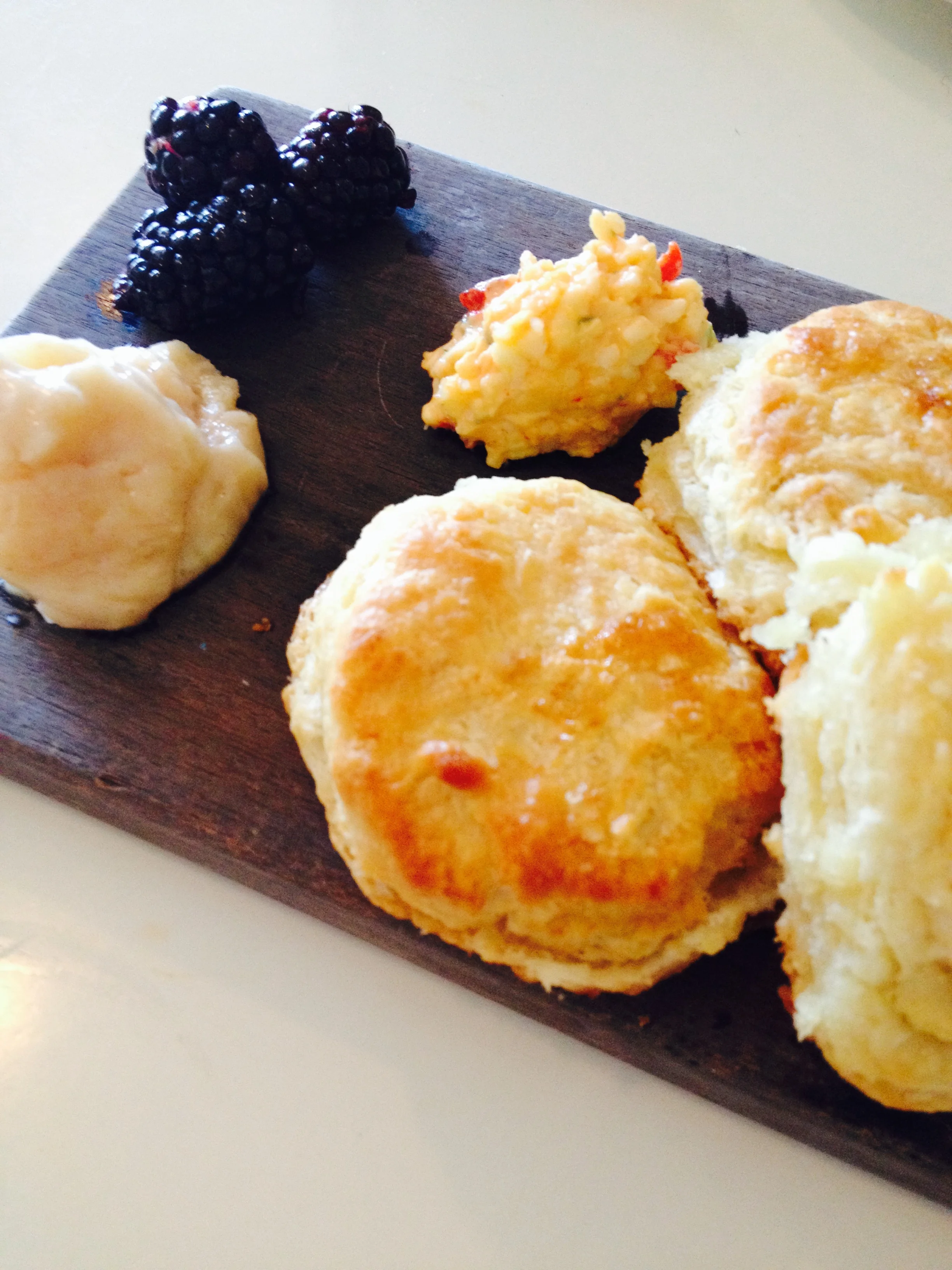 Butter biscuits with pimento cheese, honey butter, and blackberries.
