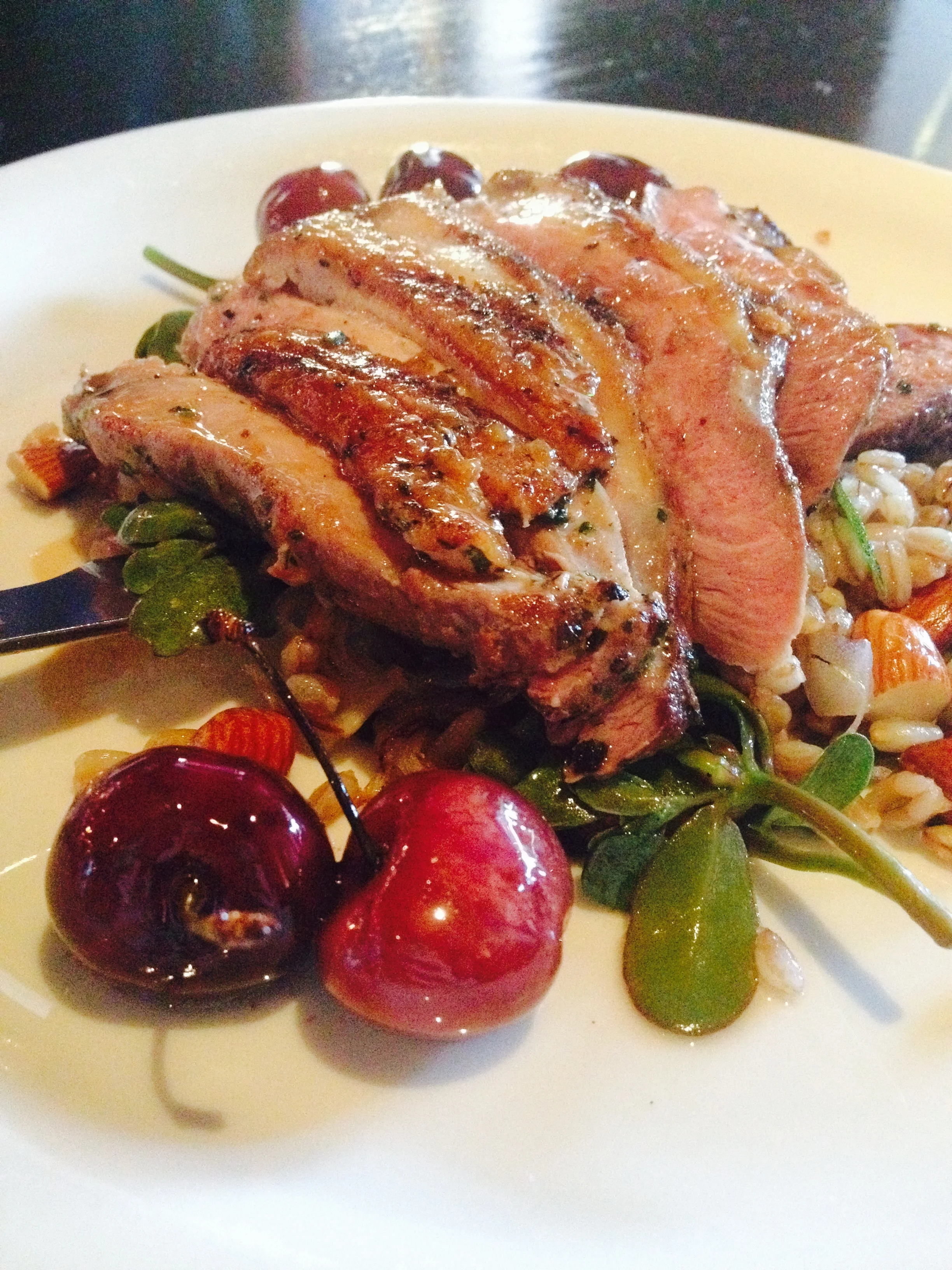 California duck breast with sautéed farro, purslane, roasted cherries, and toasted almonds.