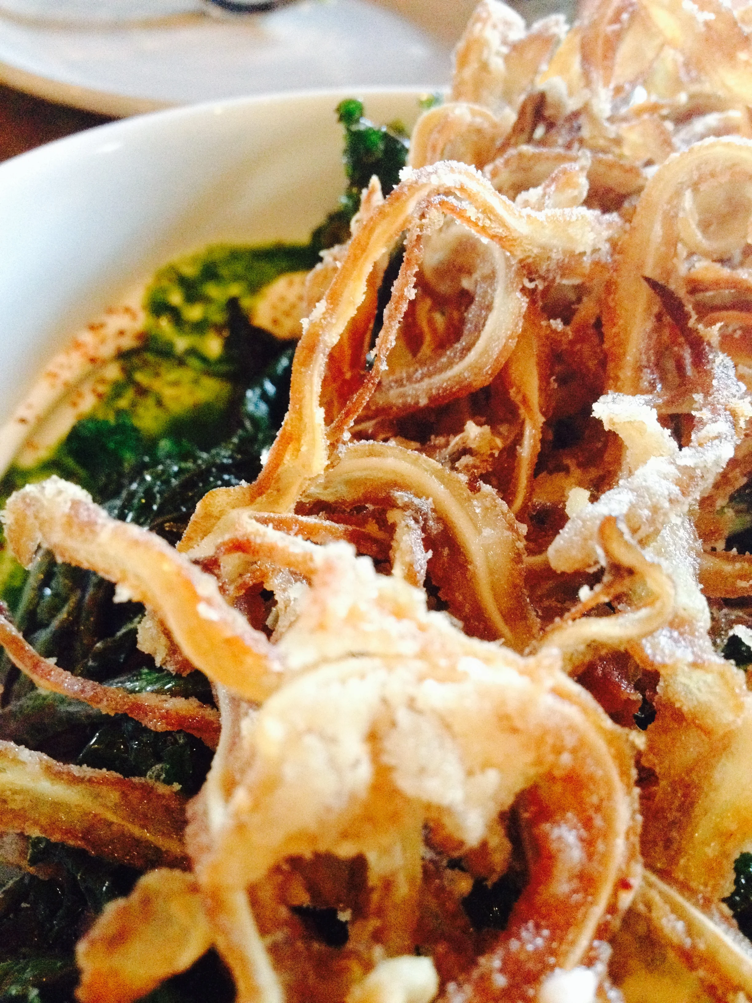 Lollipop Kale with crème fraîche, pig ears, and togarashi.