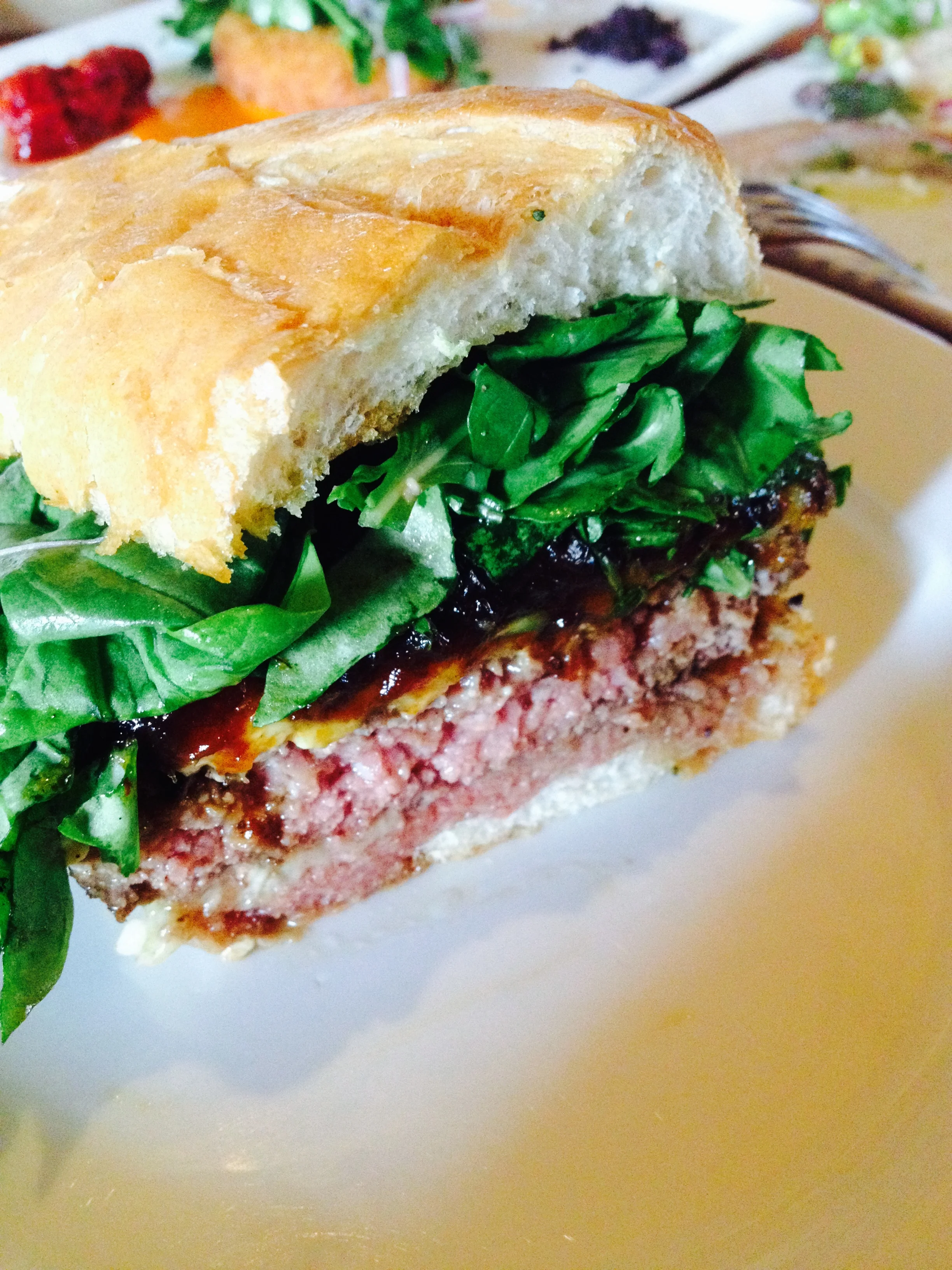 The Office Burger ® with dry-aged beef, caramelized onions, bacon, gruyère, Maytag blue cheese, and arugula.