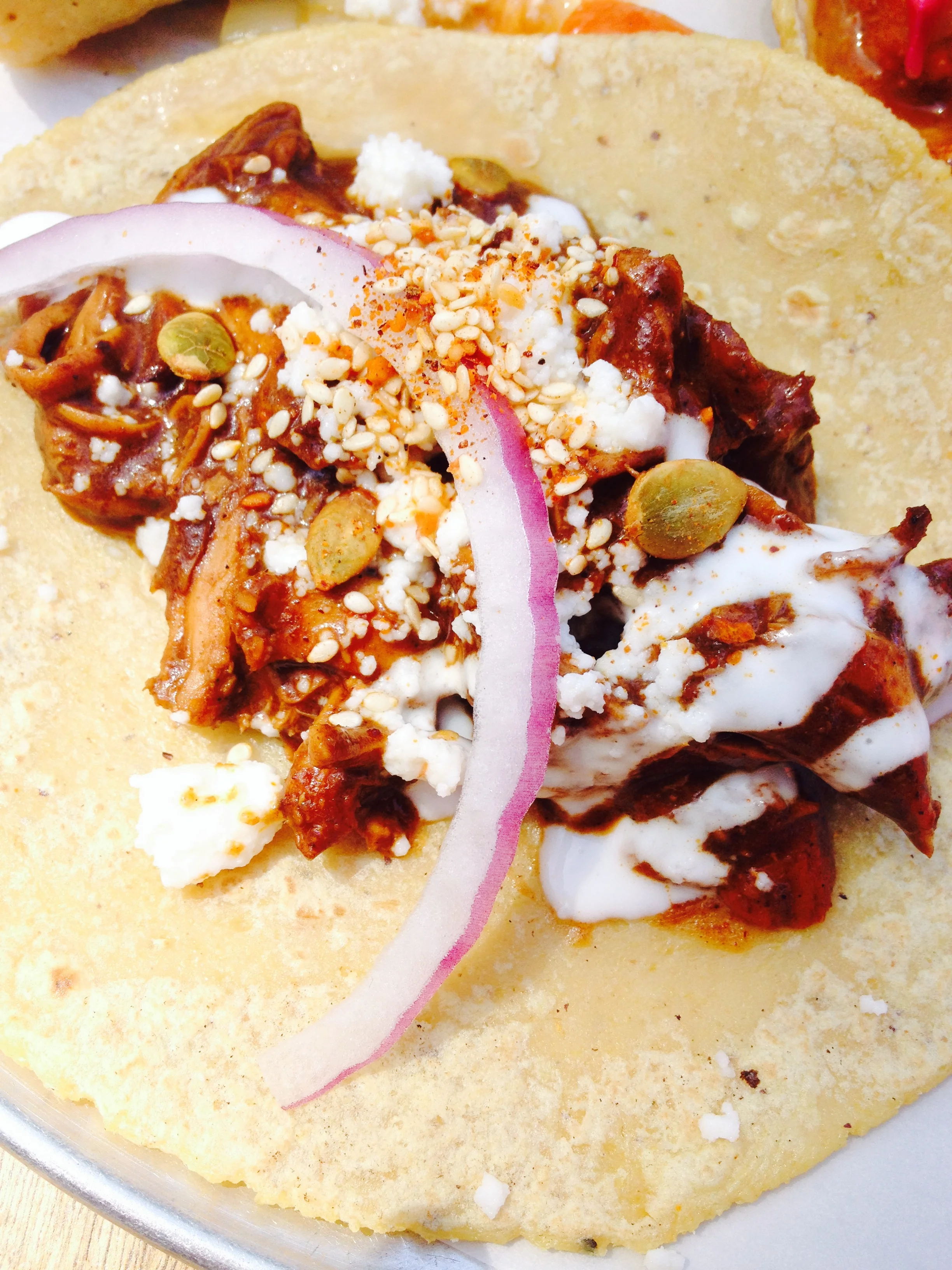 Mole Poblano with shredded chicken breast, a rich poblano style mole, sour cream, queso fresco, red onion, and dried chili.