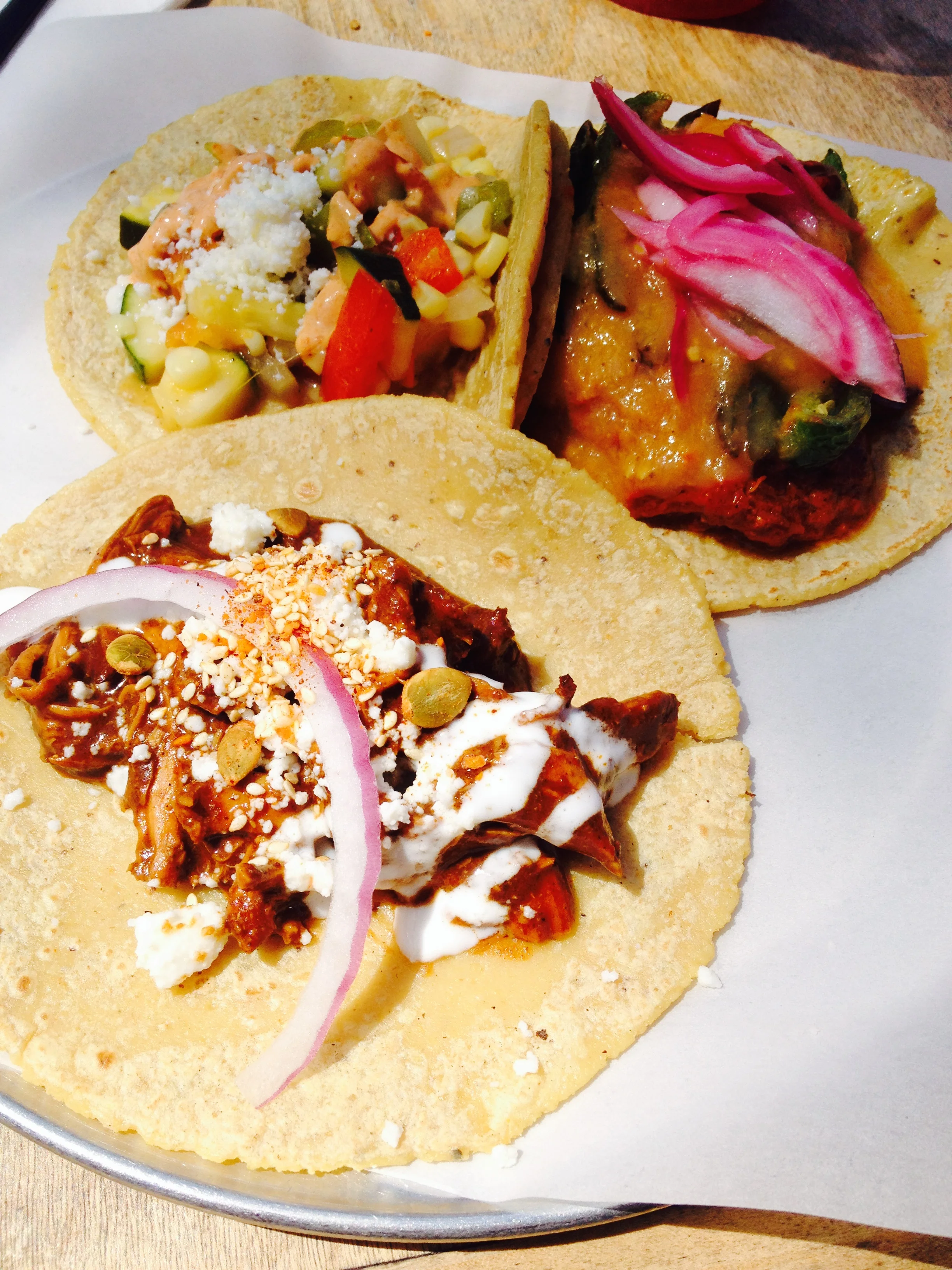 Mole Poblano (front). Cochinita Pibil served at level 10 (it’s offered from levels 1-10) with shredded pork cooked in achiote peppers on top of black beans, served with pickled onions and habanero chilies. Calabasitas with squash, tomatoes, bell peppers, corn and onions. Served with queso fresco and a mild chipotle-sour cream.