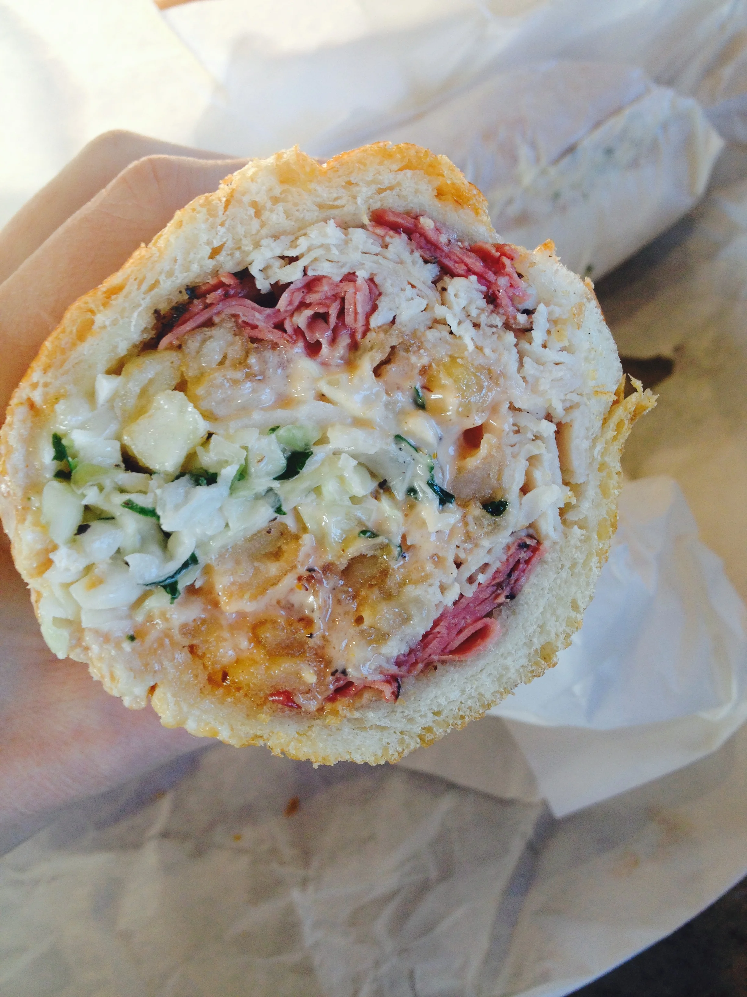 The FAT JOEY with pastrami, turkey, melted swiss, cole slaw, fries, and Russian dressing, served on a hero.