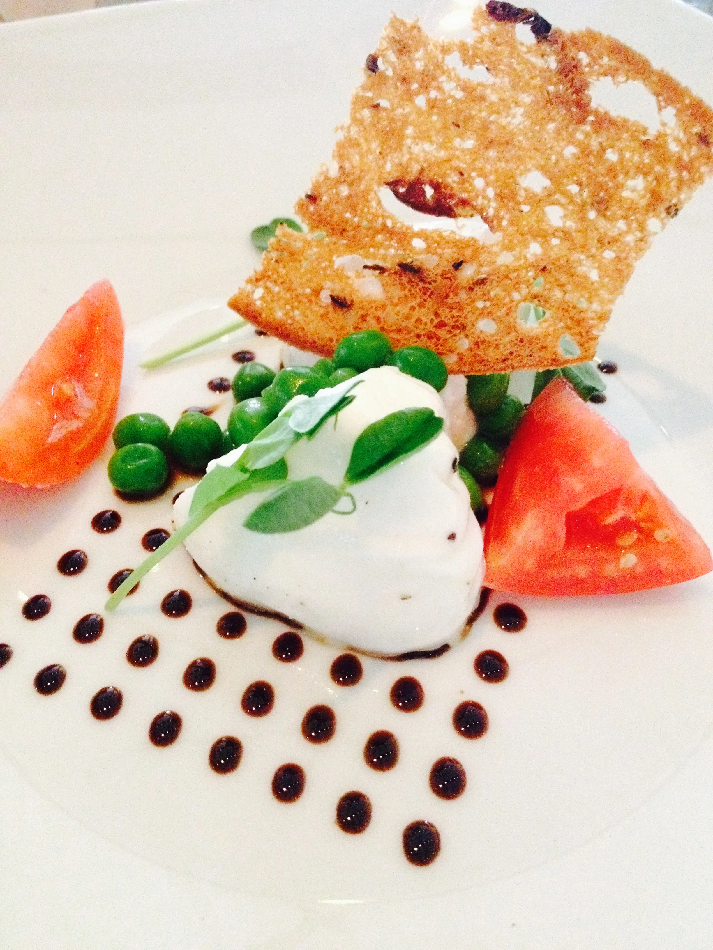 la burrata with balsamic, heirloom tomatoes, peas, and crostini.
