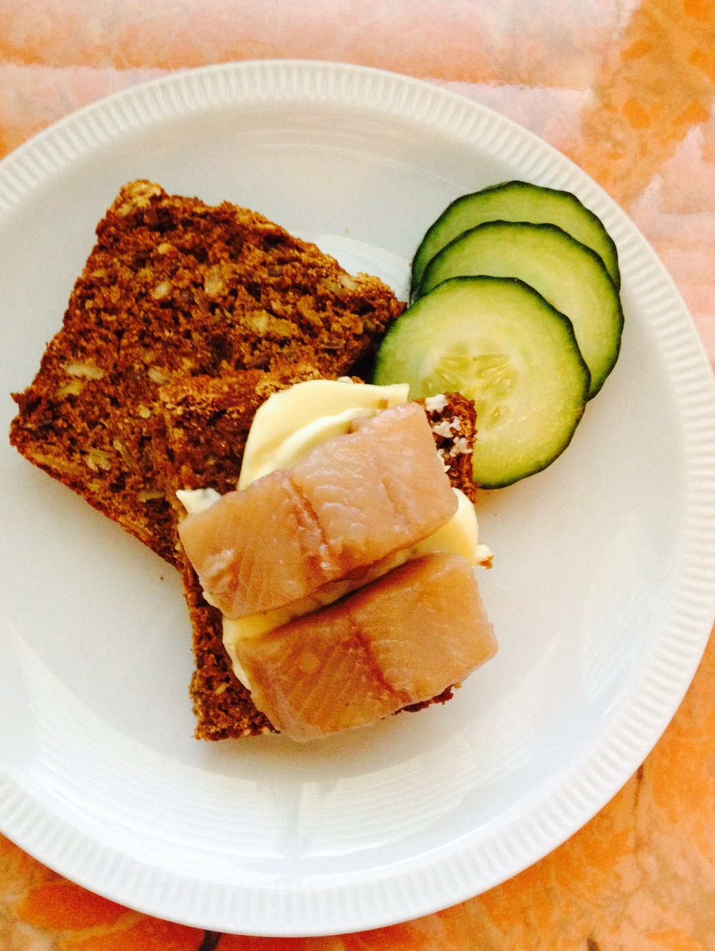 Open-faced sandwich with Danish butter, pickled herring, and cucumber.
