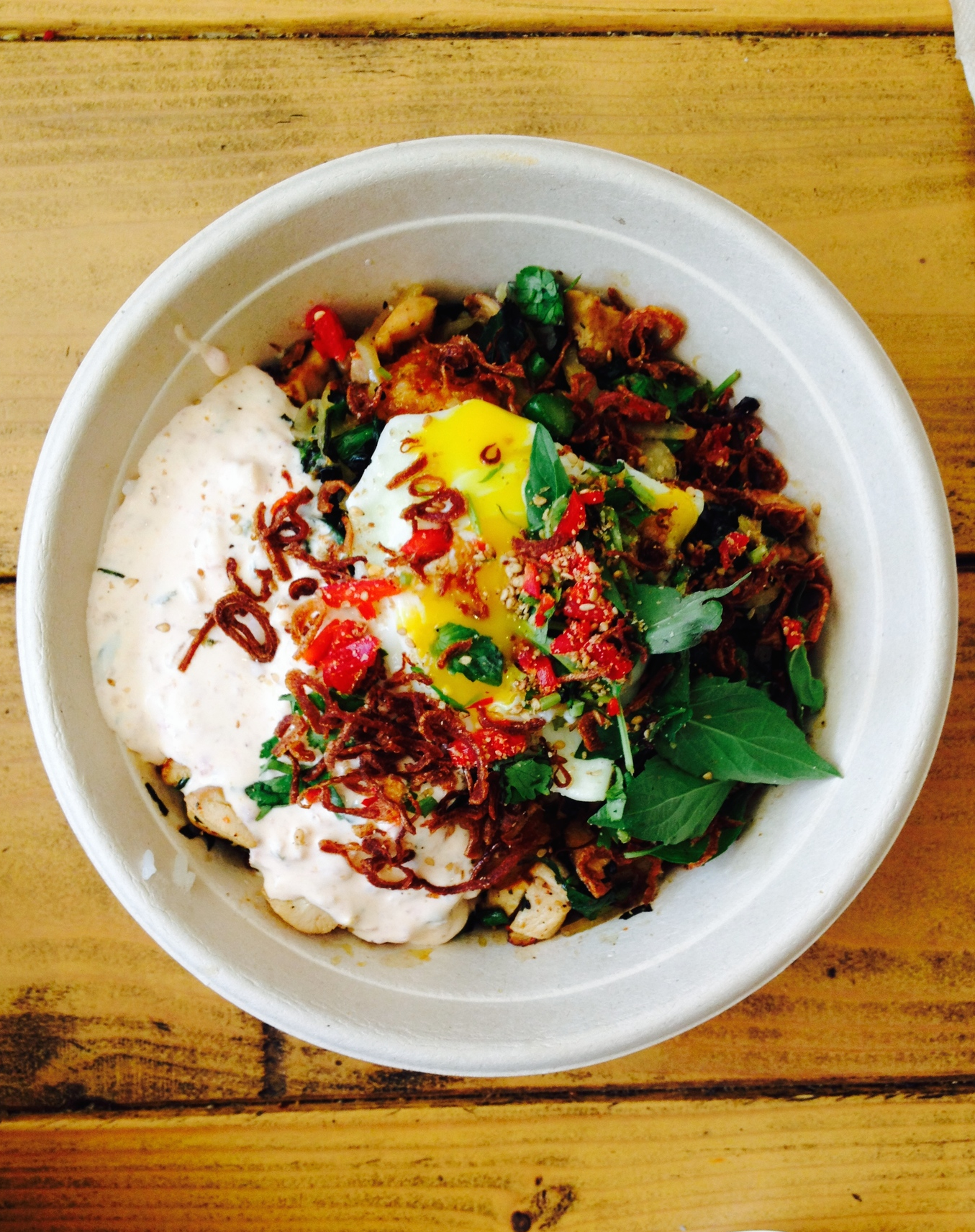 Sour Cream Hen House - marinated grilled chicken rice bowl with fried egg, Chinese broccoli, sour cream sambal, Thai basil, toasted sesame, and red jalapeño.
