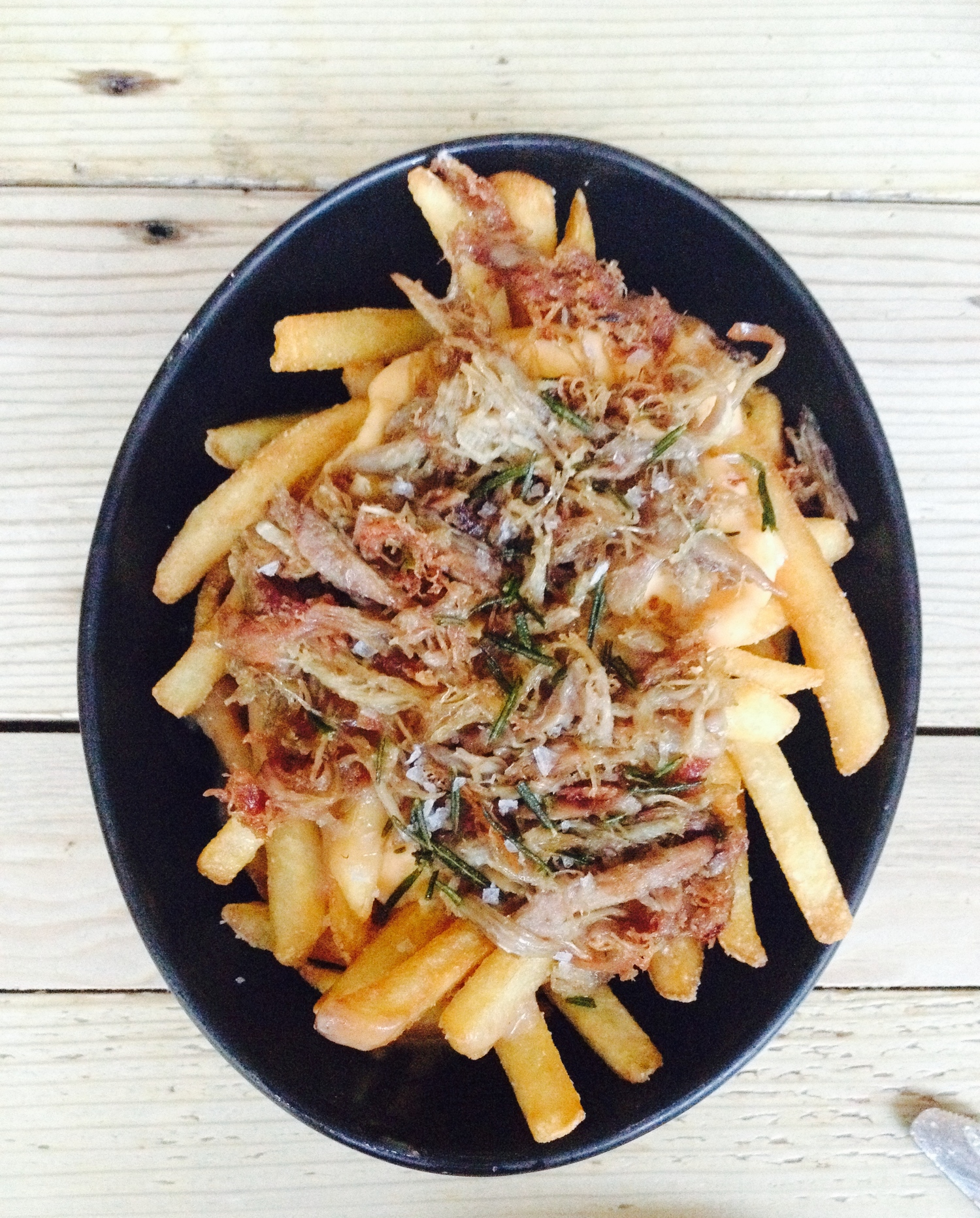 Duck confit poutine with gravy, cheddar mornay, and fried rosemary