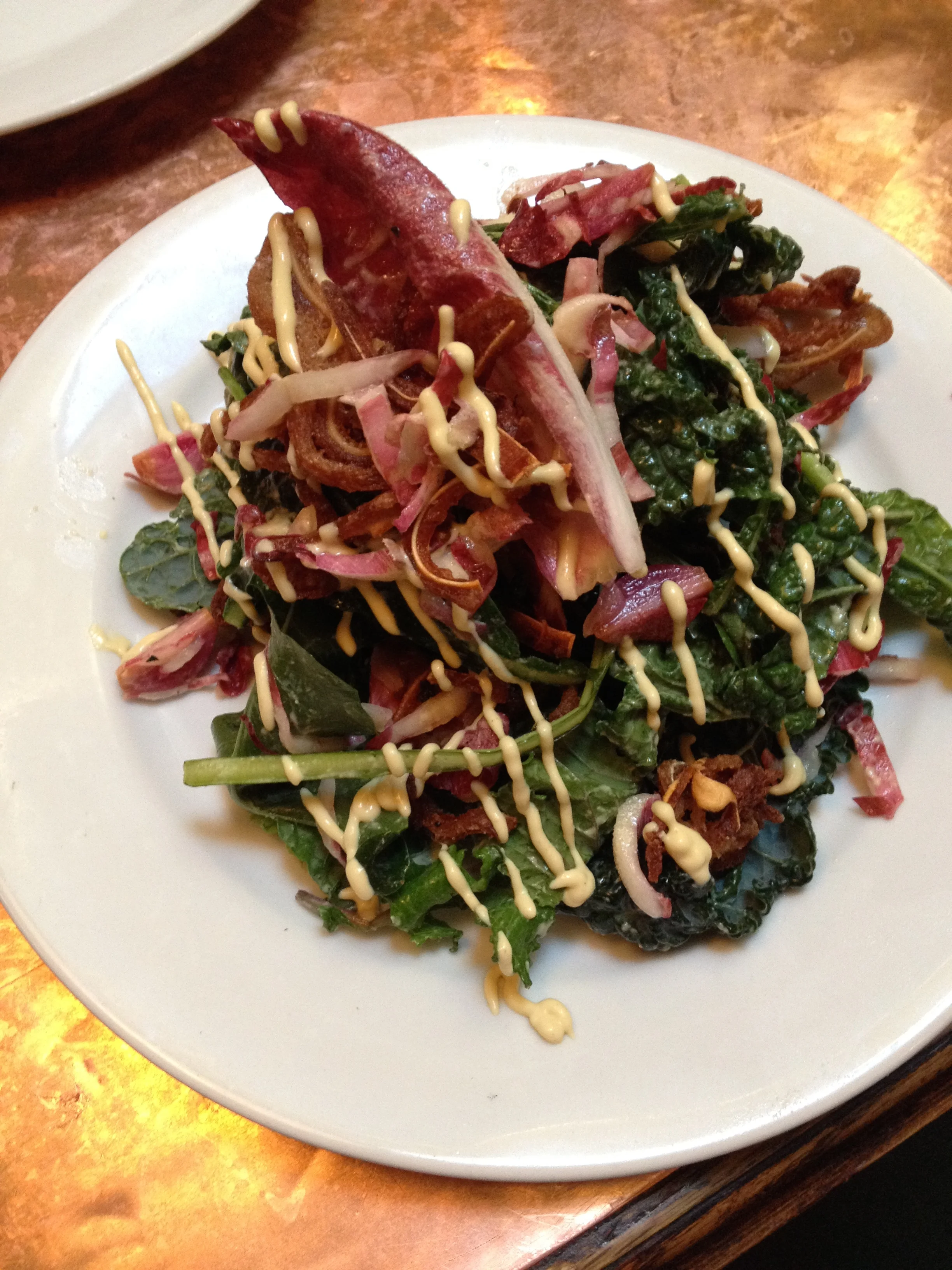 Crispy Pig's Ear Salad with young kale, endive, pickled onions, and mustard dressing