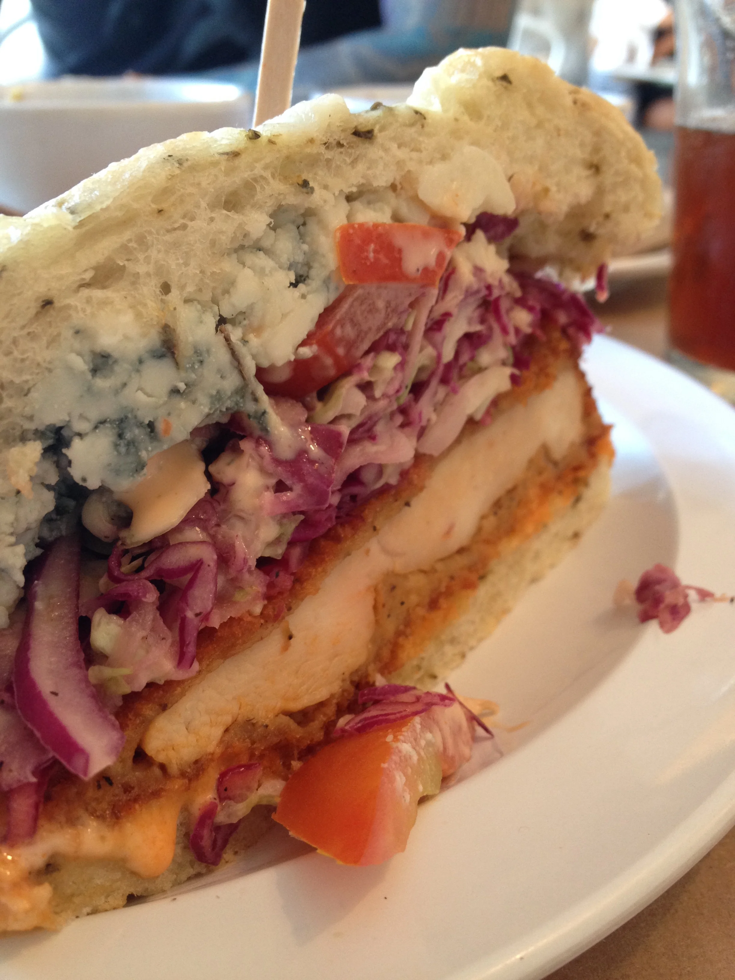 Fried Chix Sandwich with free range chicken breast, cumin coleslaw, tomato, tabasco mayo, bleu cheese, and Buffalo Memphis sauce on an onion focaccia.