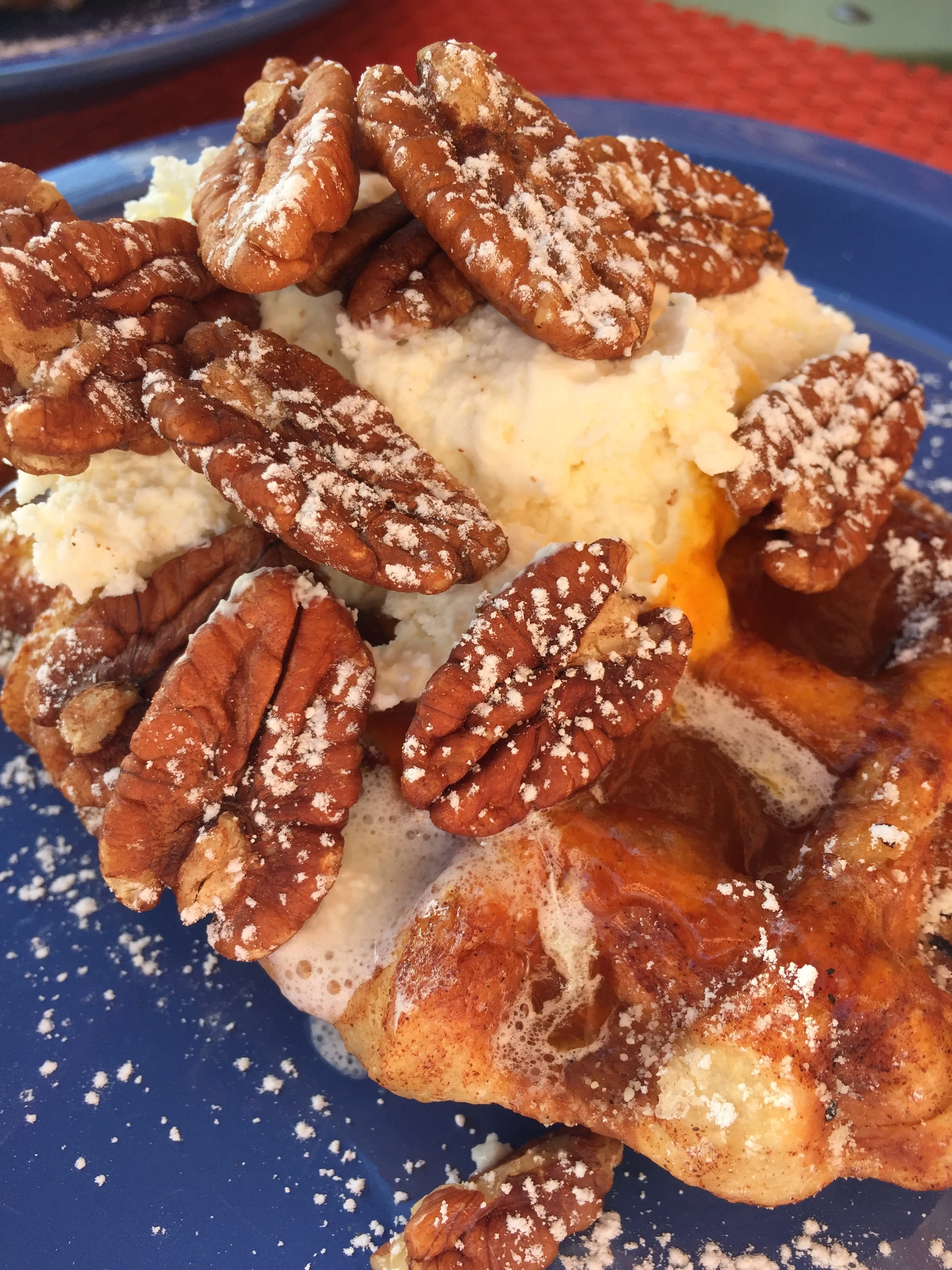 Seasonal Liege Waffle topped with Pumpkin, Whipped Cream, Pecans, and Powdered Sugar.