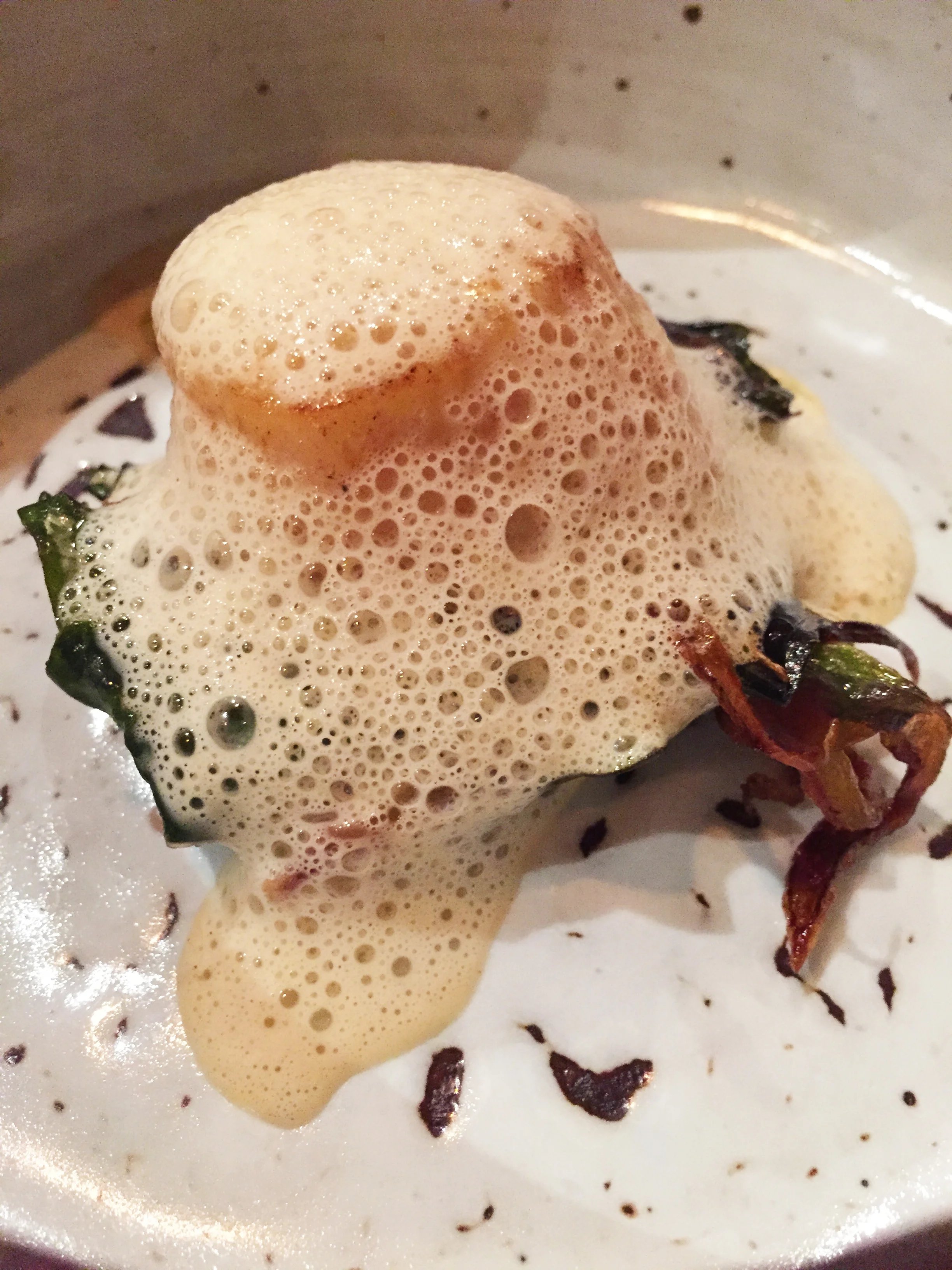 Pan roasted Muki Hoate sushi grade Scallop, with "lobster bisque," cauliflower leaves, and lime.