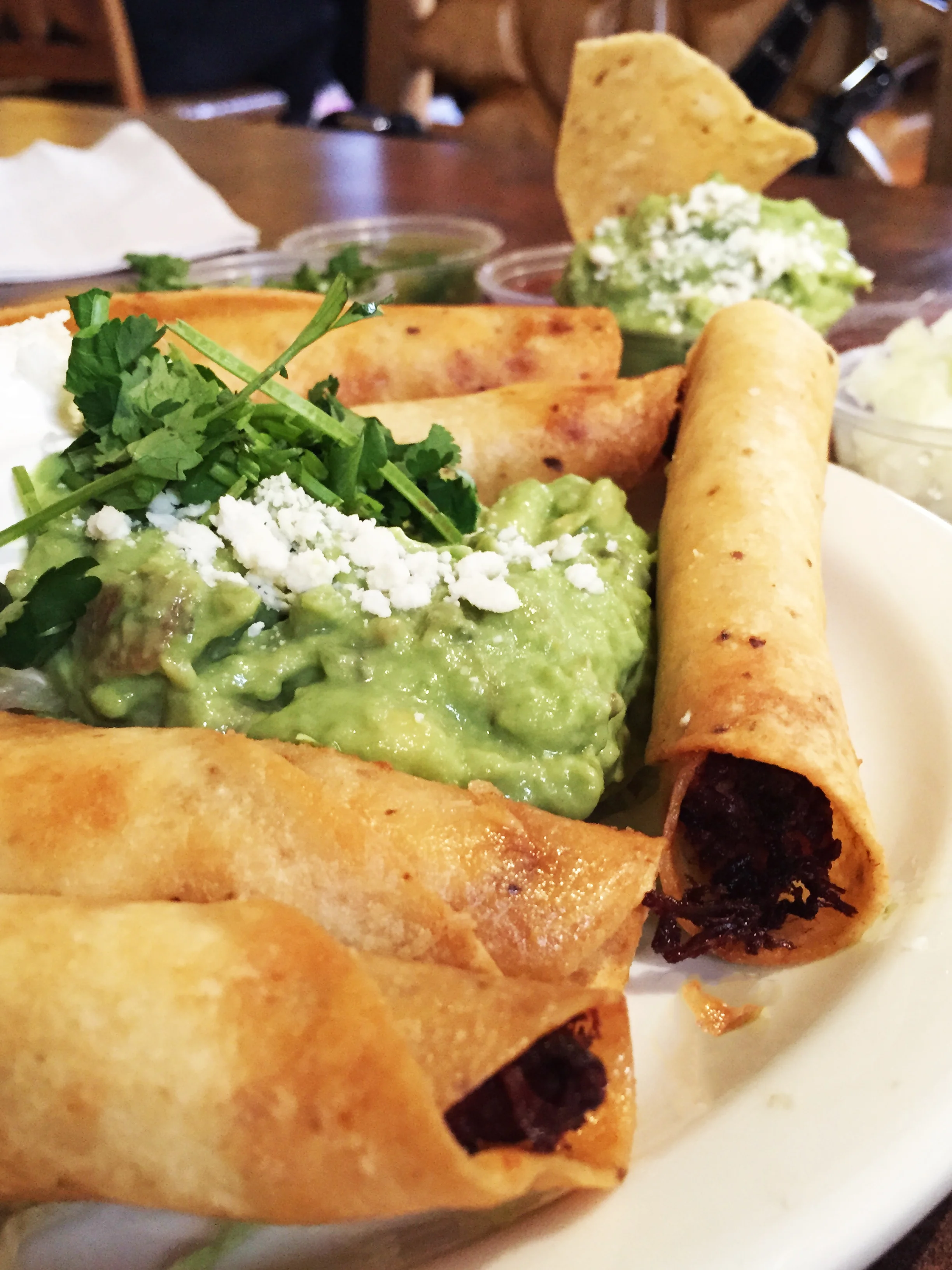 Chicken Taquito Bites with guacamole and sour cream.