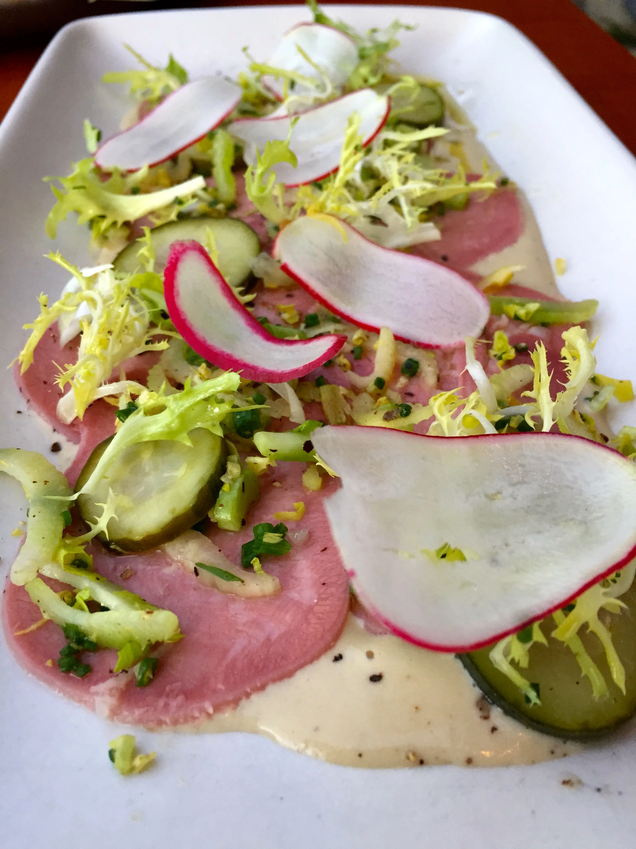 Veal Tongue Tonnato with radishes, pickles, and cicoria.