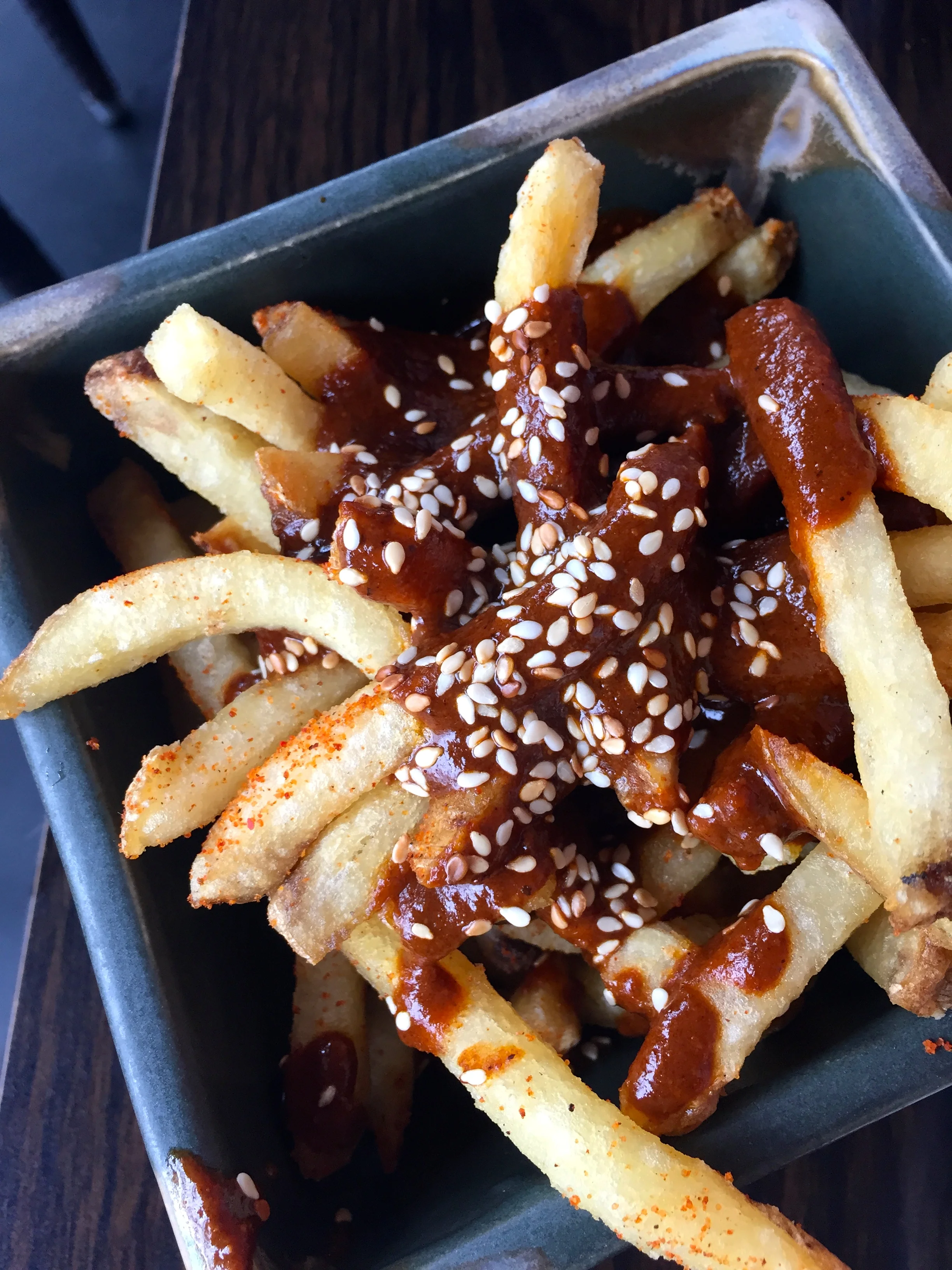 Mission Fig Mole French Fries - house-made fries topped with mission fig mole poblano sauce, topped with sesame seeds.