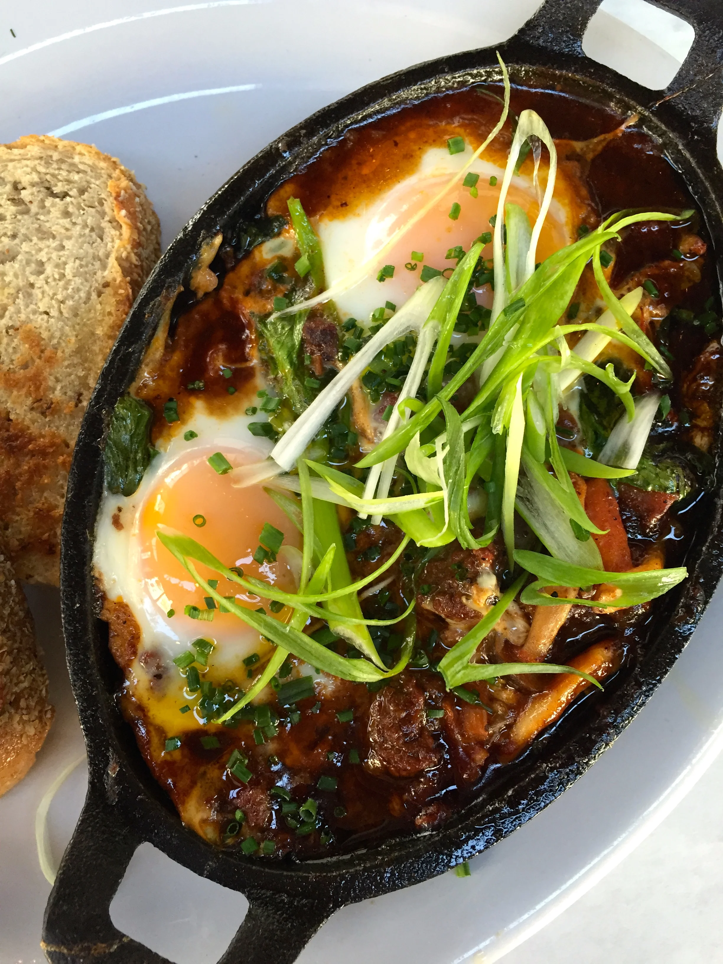 Baked Eggs en Cocotte with tomato, beef, and green chile.