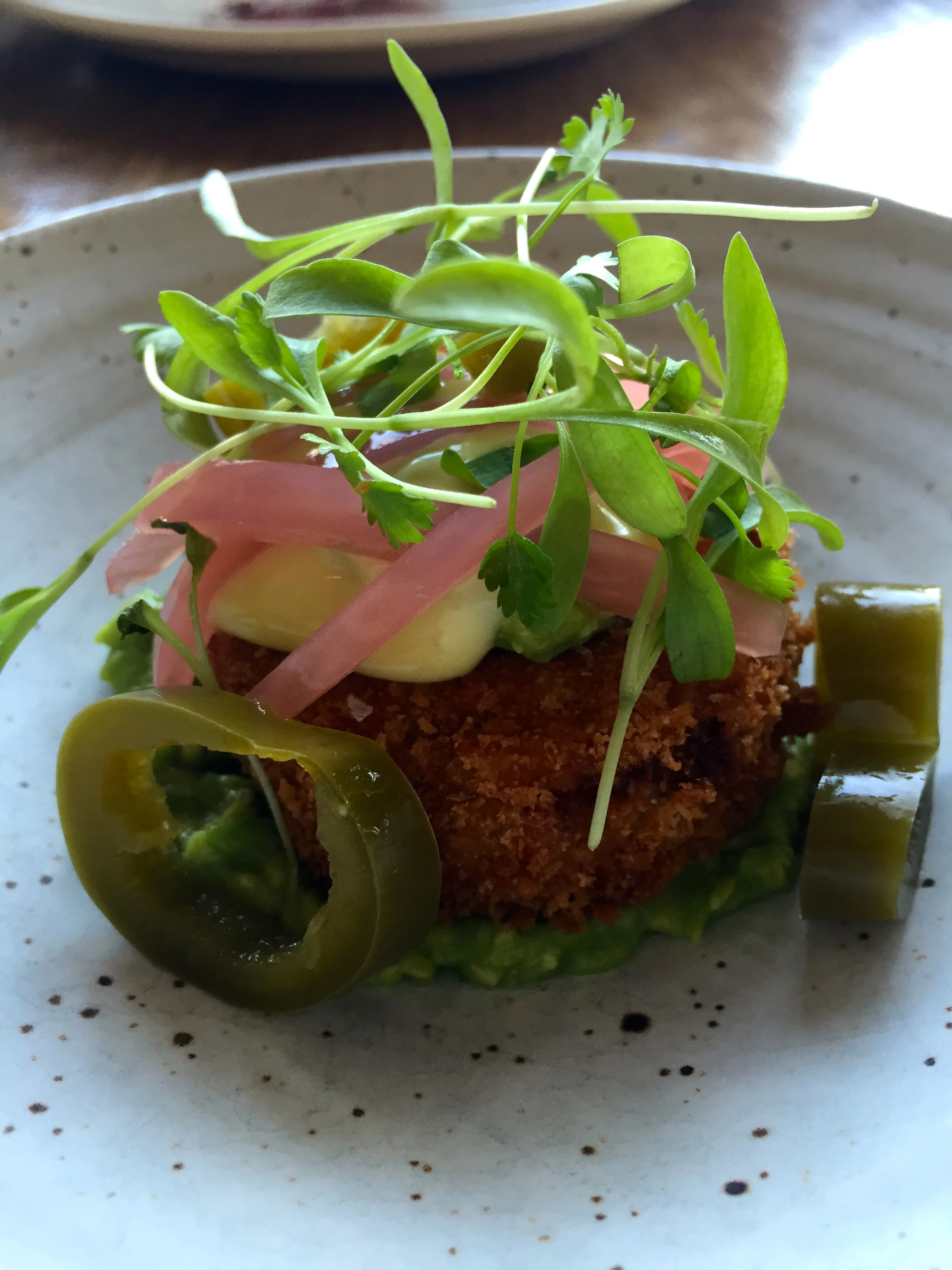Fried cook pigs pork trotter “milanesa” avocado, pickled onion & jalapeno, cilantro, and aioli.