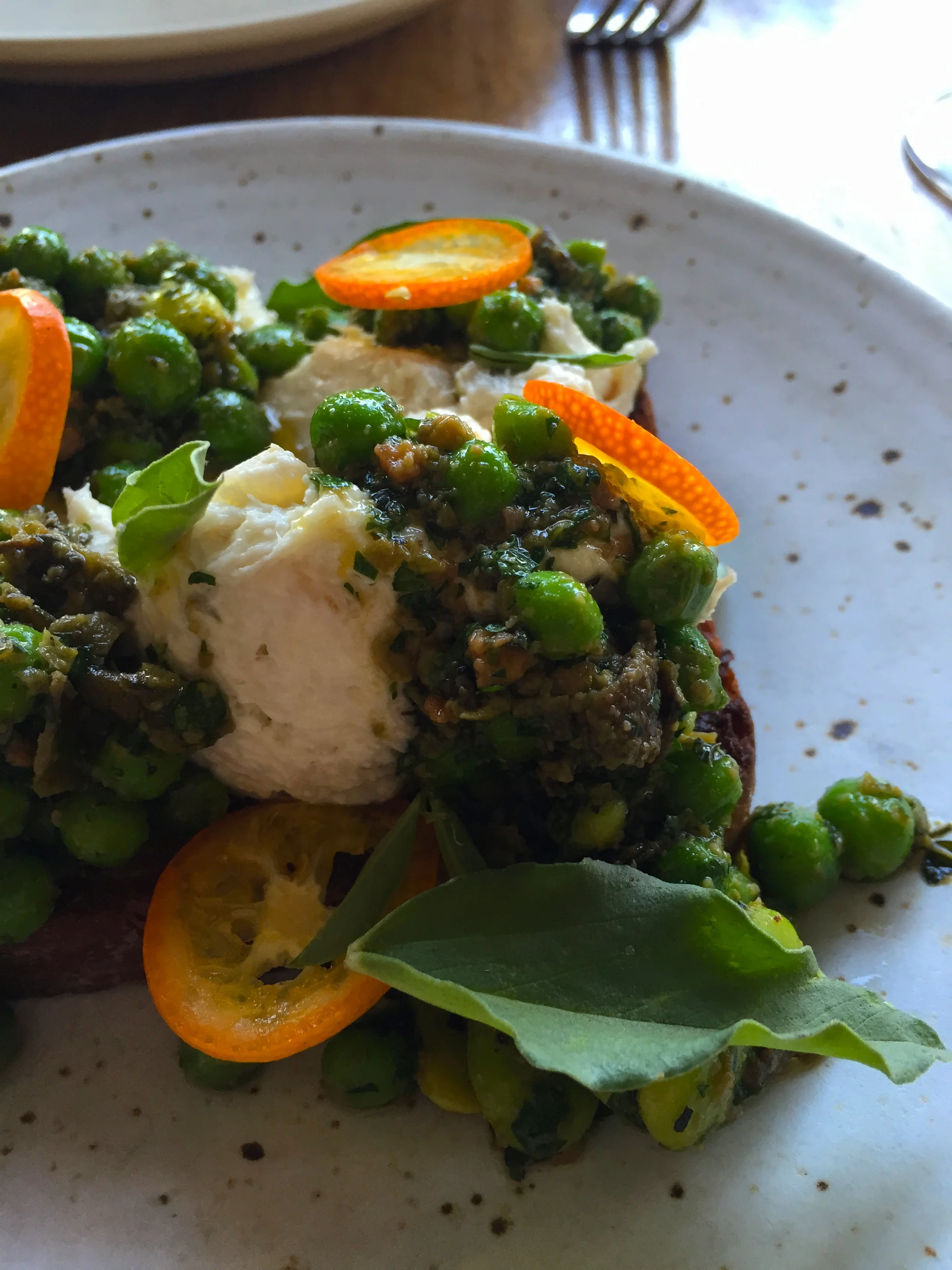 Cherry-smoked SB black cod tqrtine with fava beans & peas, and roasted fava pod-almond "maro" and brioche.