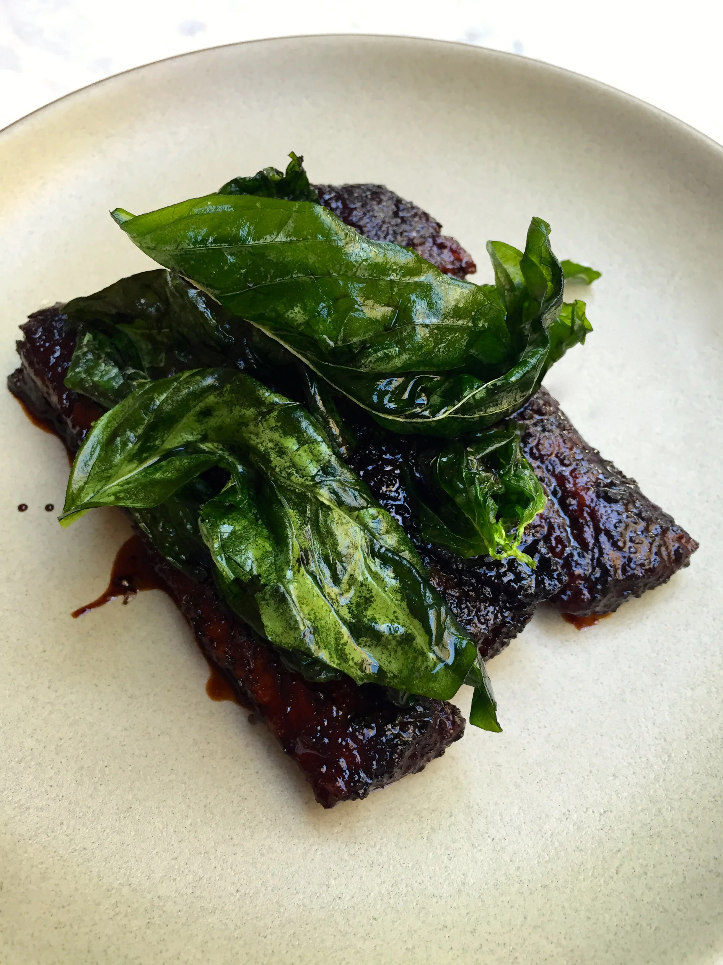 Balsamic glazed ribs with aleppo pepper and fried basil.