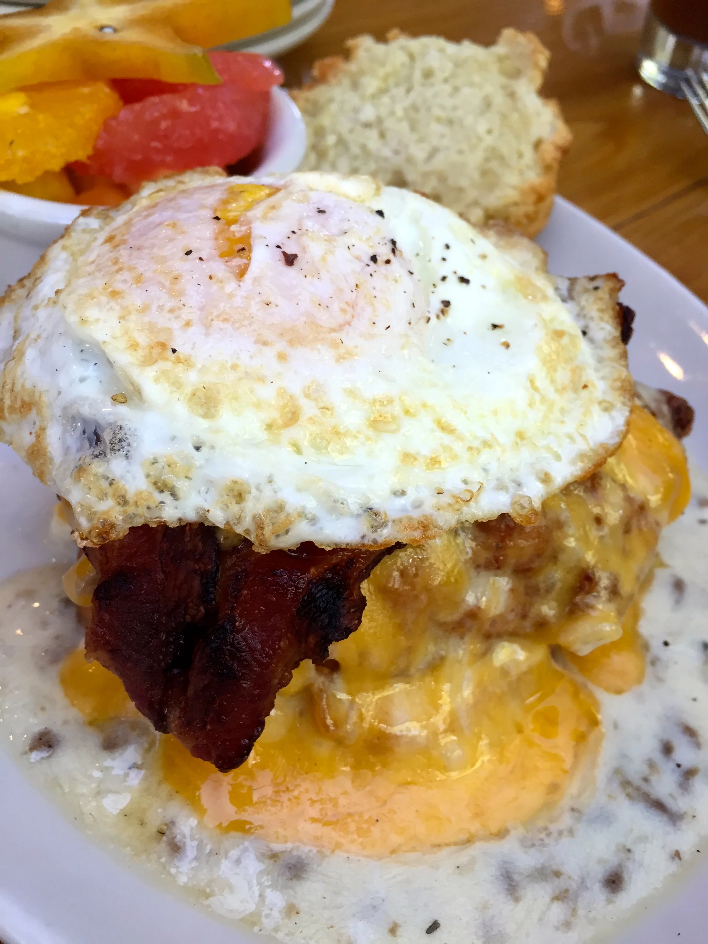SxSW fried chicken, country gravy, bacon, cheddar, egg on a biscuit served with fruit.