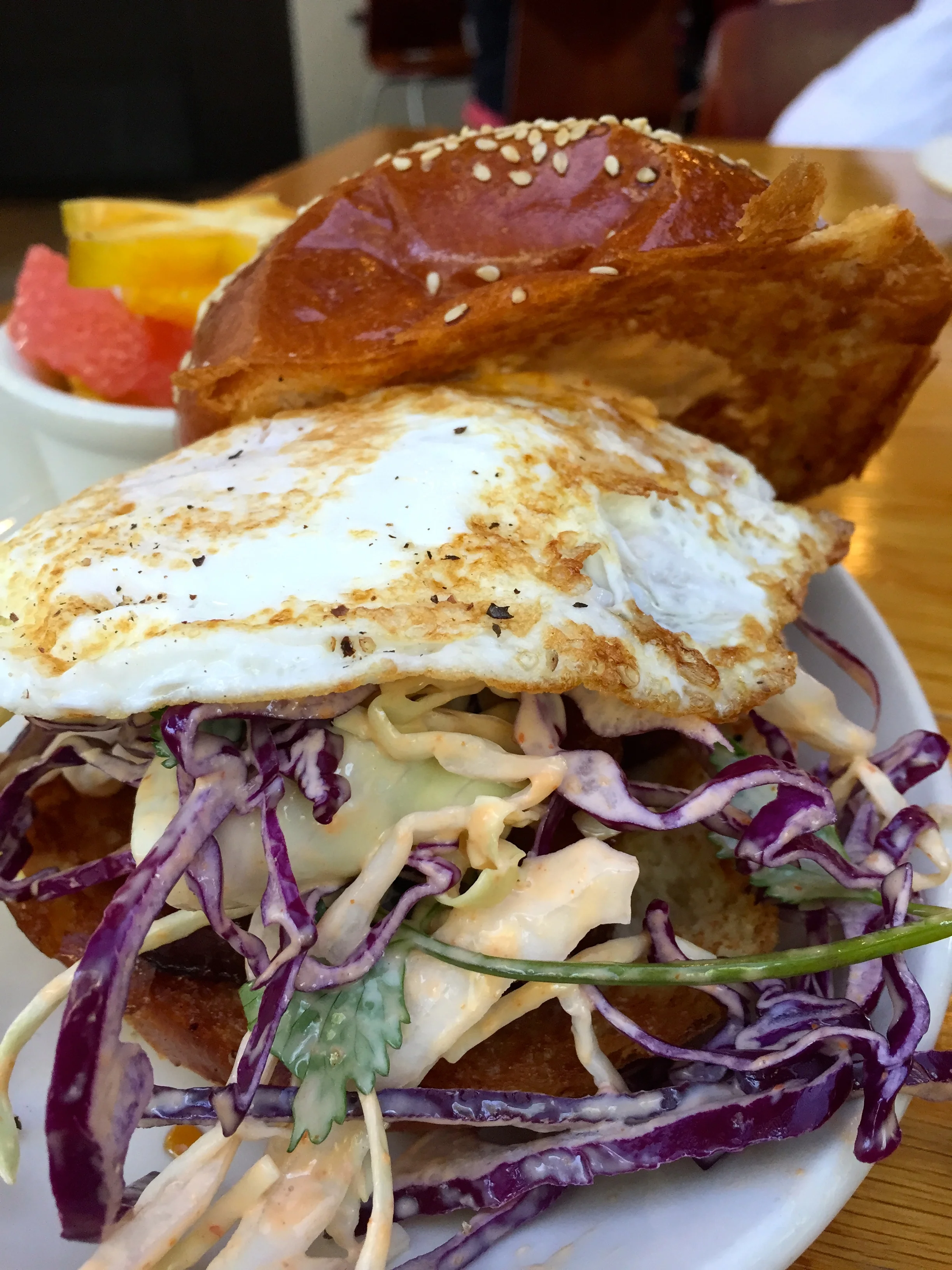 BREAKFAST SANDO house made “east” sausage, egg, red chili aioli, cilantro slaw, brioche.