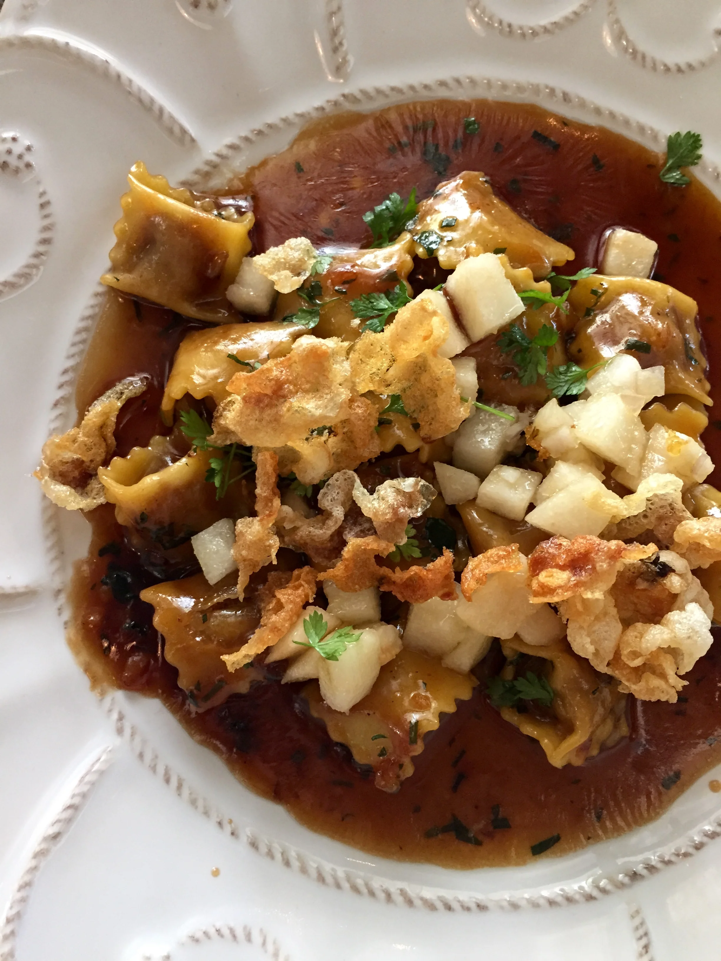 Oxtail Agnolotti with Asian pear conserva, bone marrow butter, and beef tendon chicharrones.
