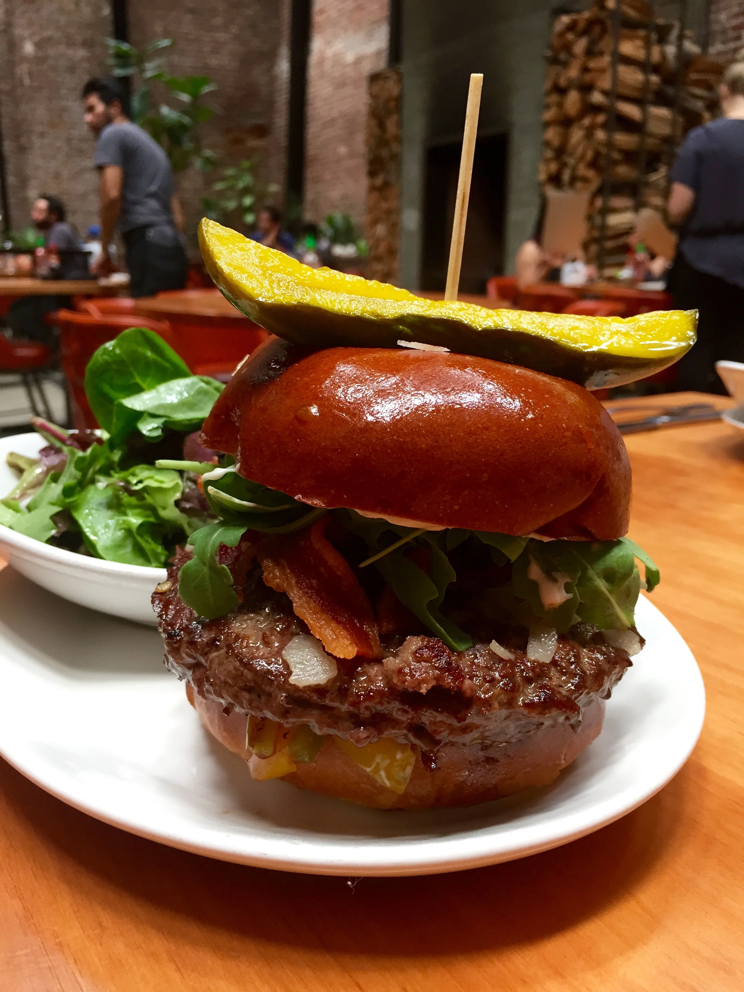 Mohawk Burger with arugula, parmesan, crispy bacon, red onion, roasted peppers, and rosemary aioli.