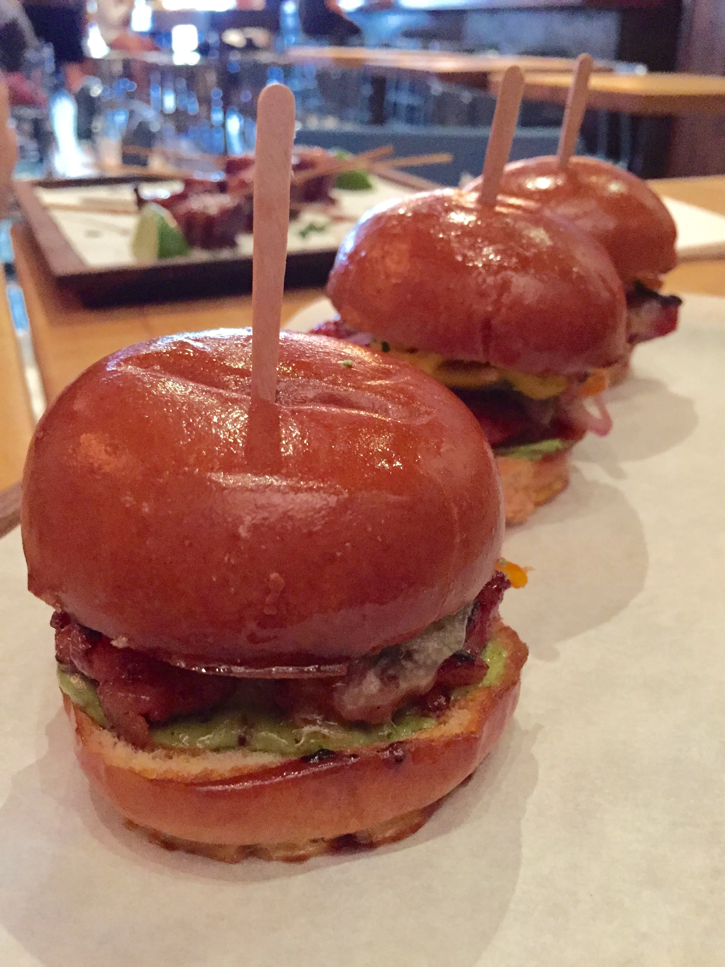 Chorizo Sliders with pickled sweet and spicy peppers, avocado emulsion, and white cheddar.